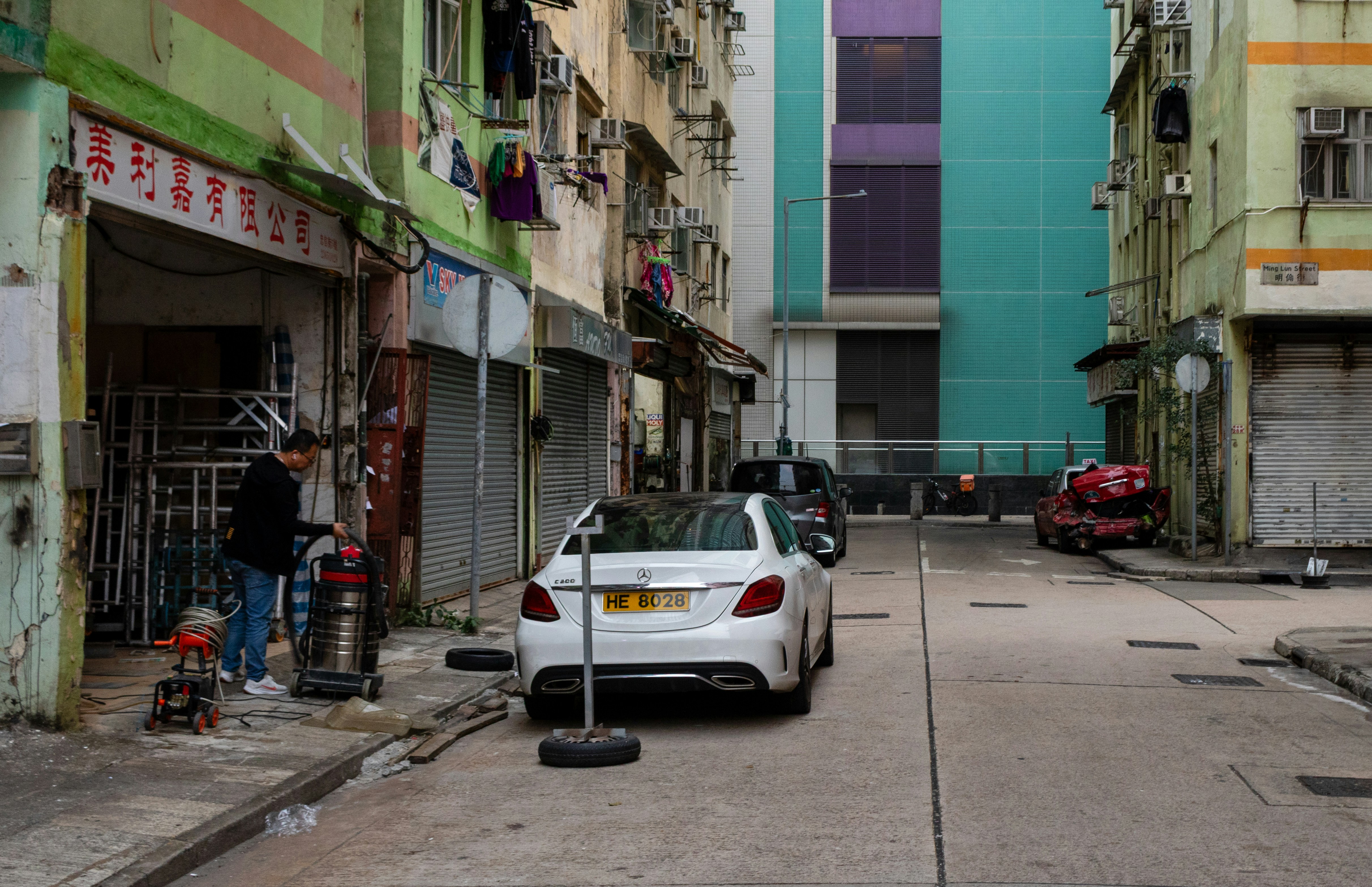 Eine Person, die einen Staubsauger auf einer Straße in Hongkong benutzt.