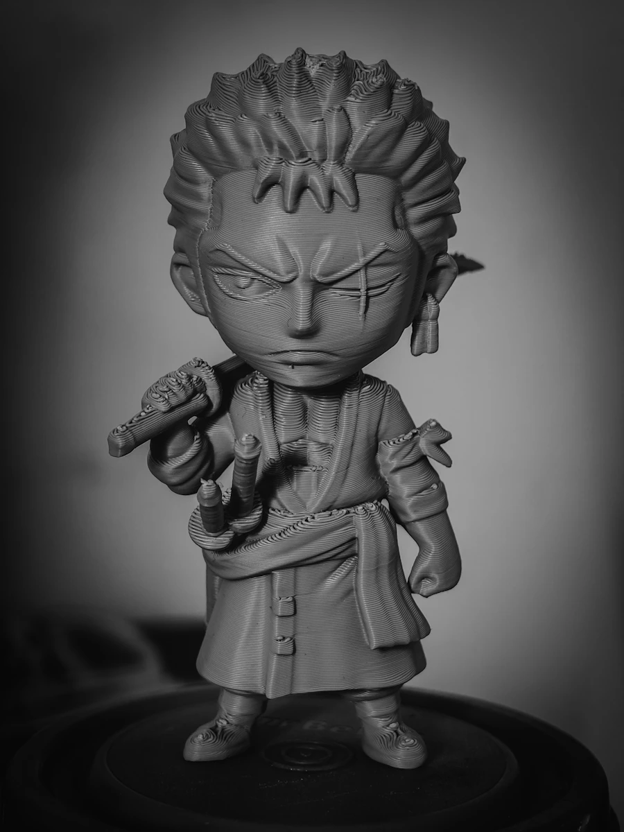 An unpainted grey resin figurine fresh off the printer, every sculpted detail still visible