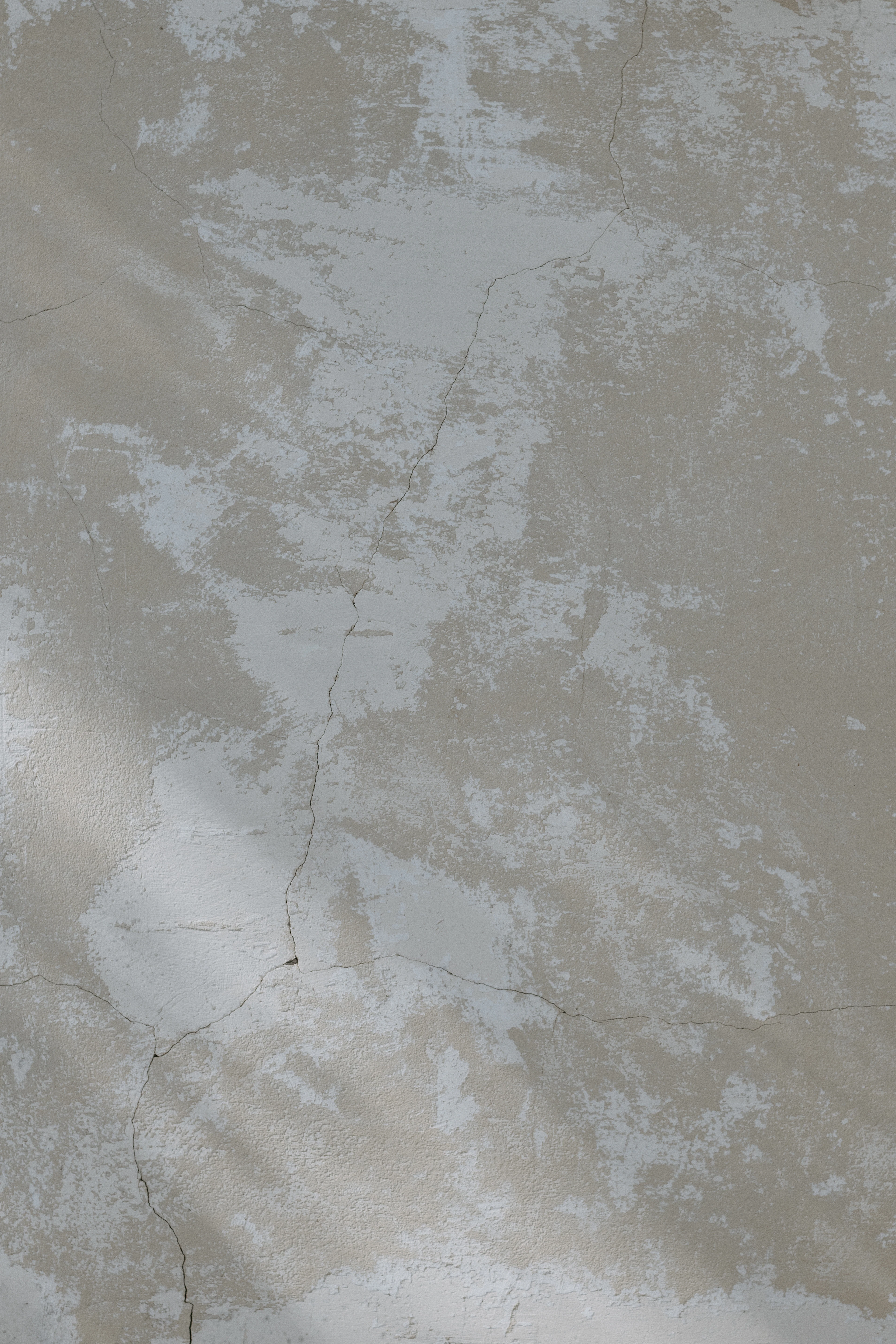 Weathered beige wall with peeling paint