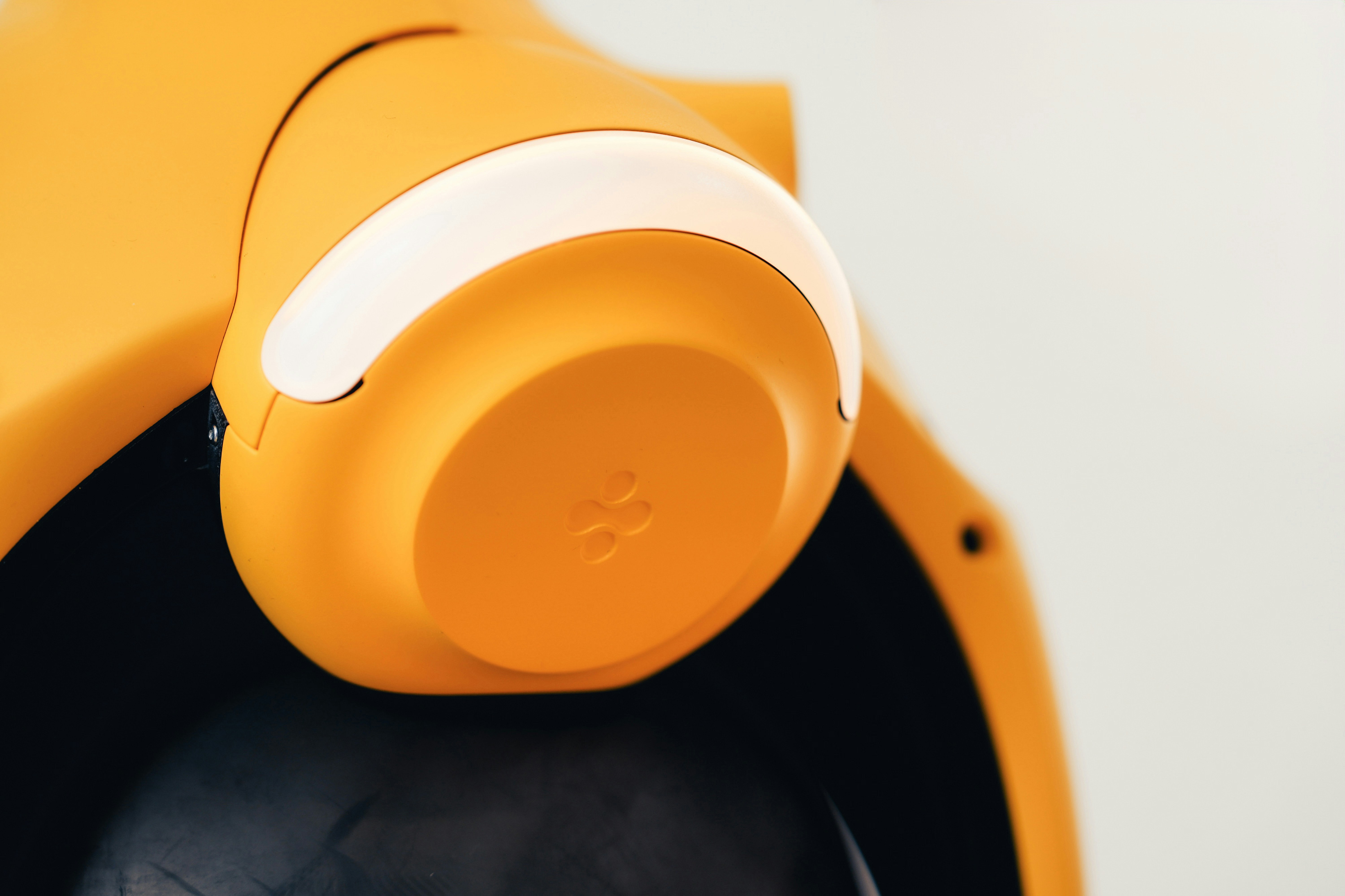 A yellow plastic object with a curved white light strip and embossed logo
