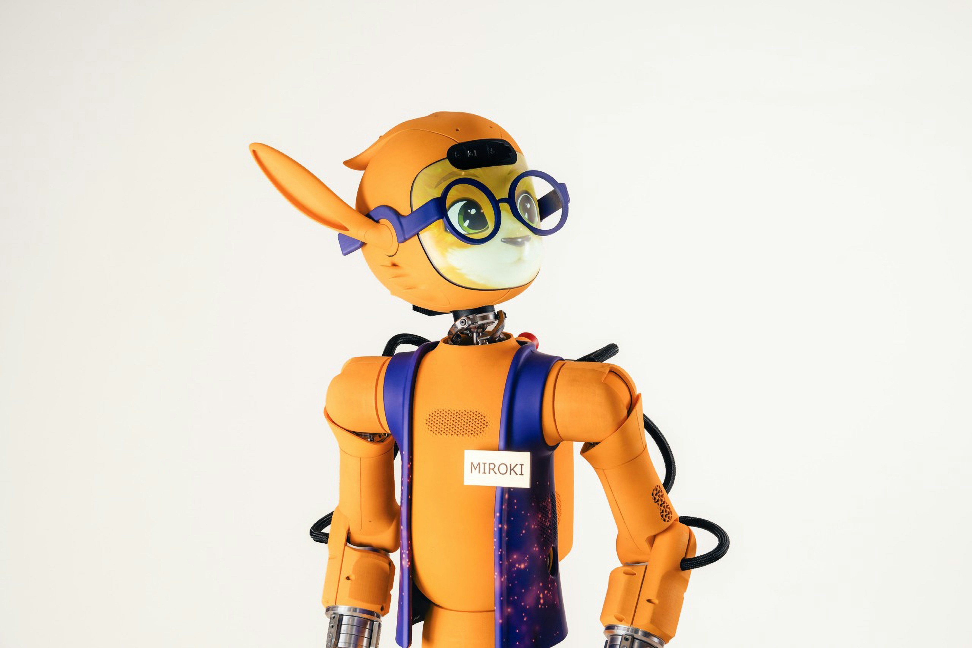 An orange robot with large ears and glasses wearing a vest labeled Miroki