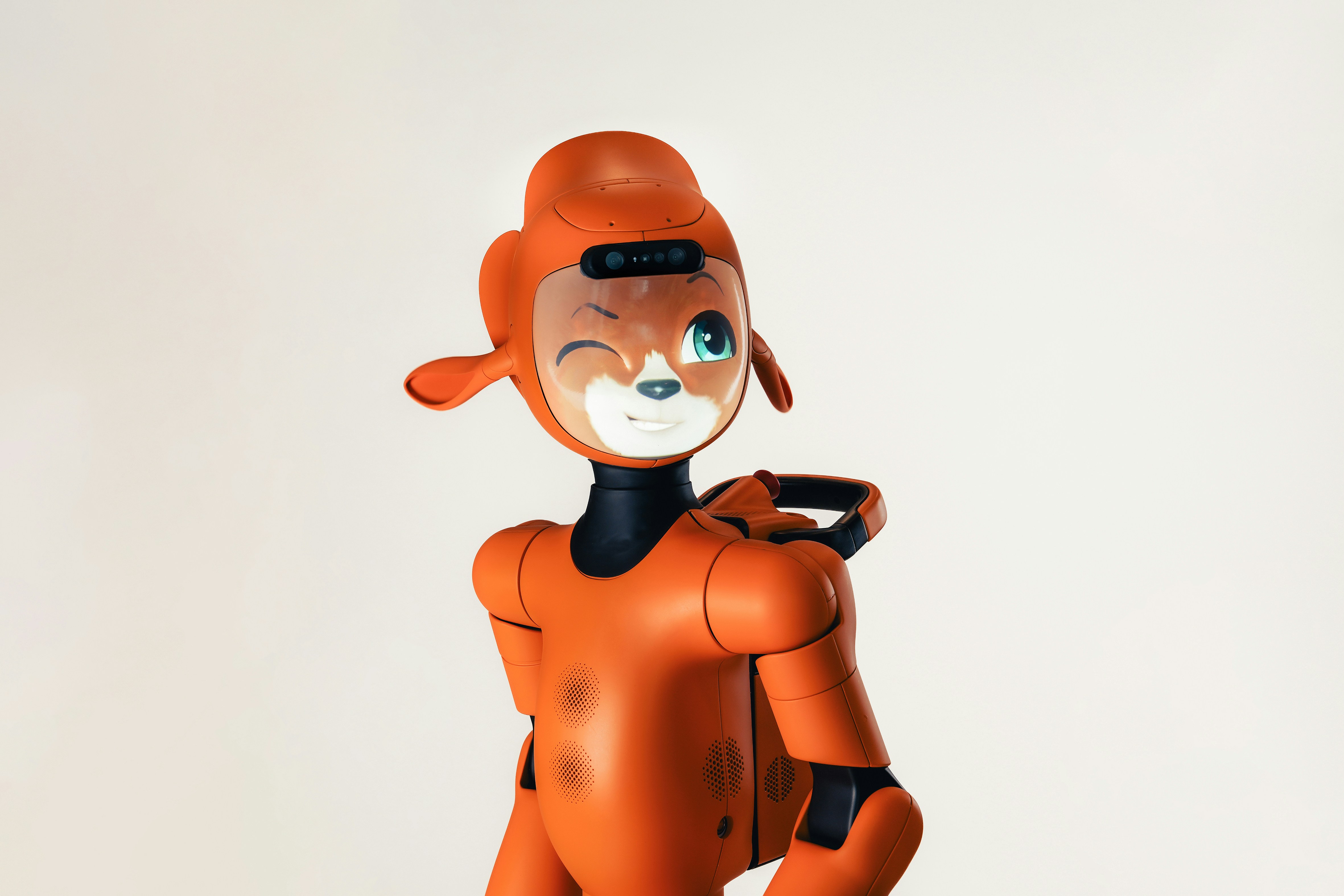 An orange humanoid robot with a winking animal face on a plain background