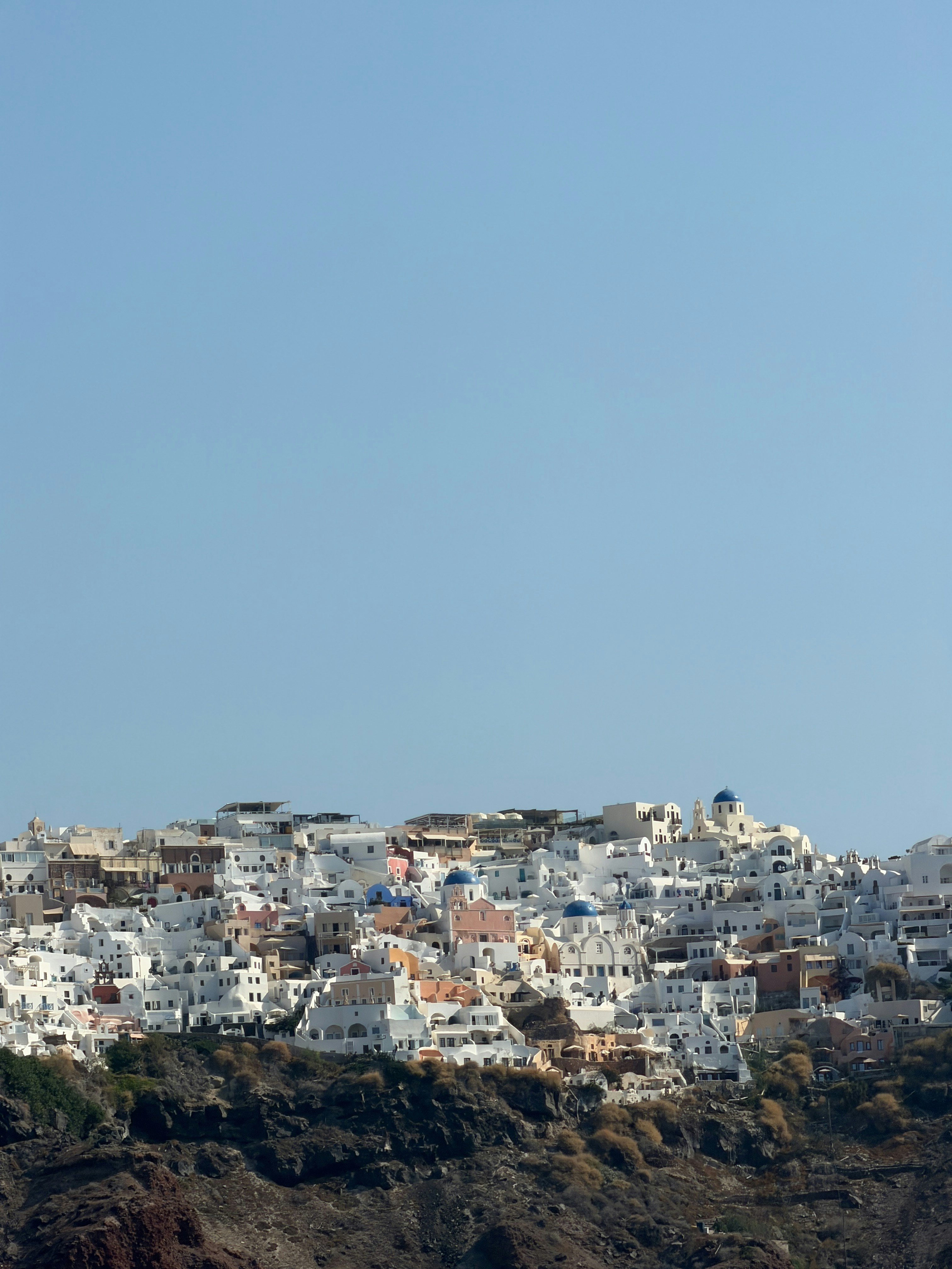 White buildings with blue domes on a cliffside in Oia, Santorini