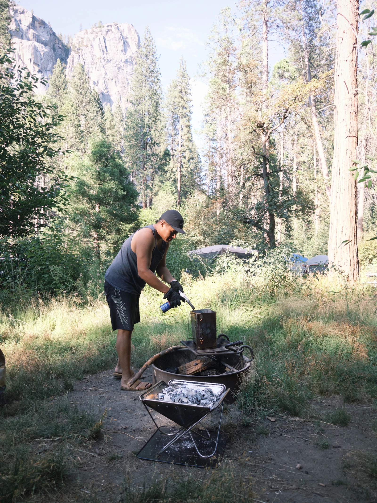 Outdoor campsite cooking equipment being prepared in a natural setting