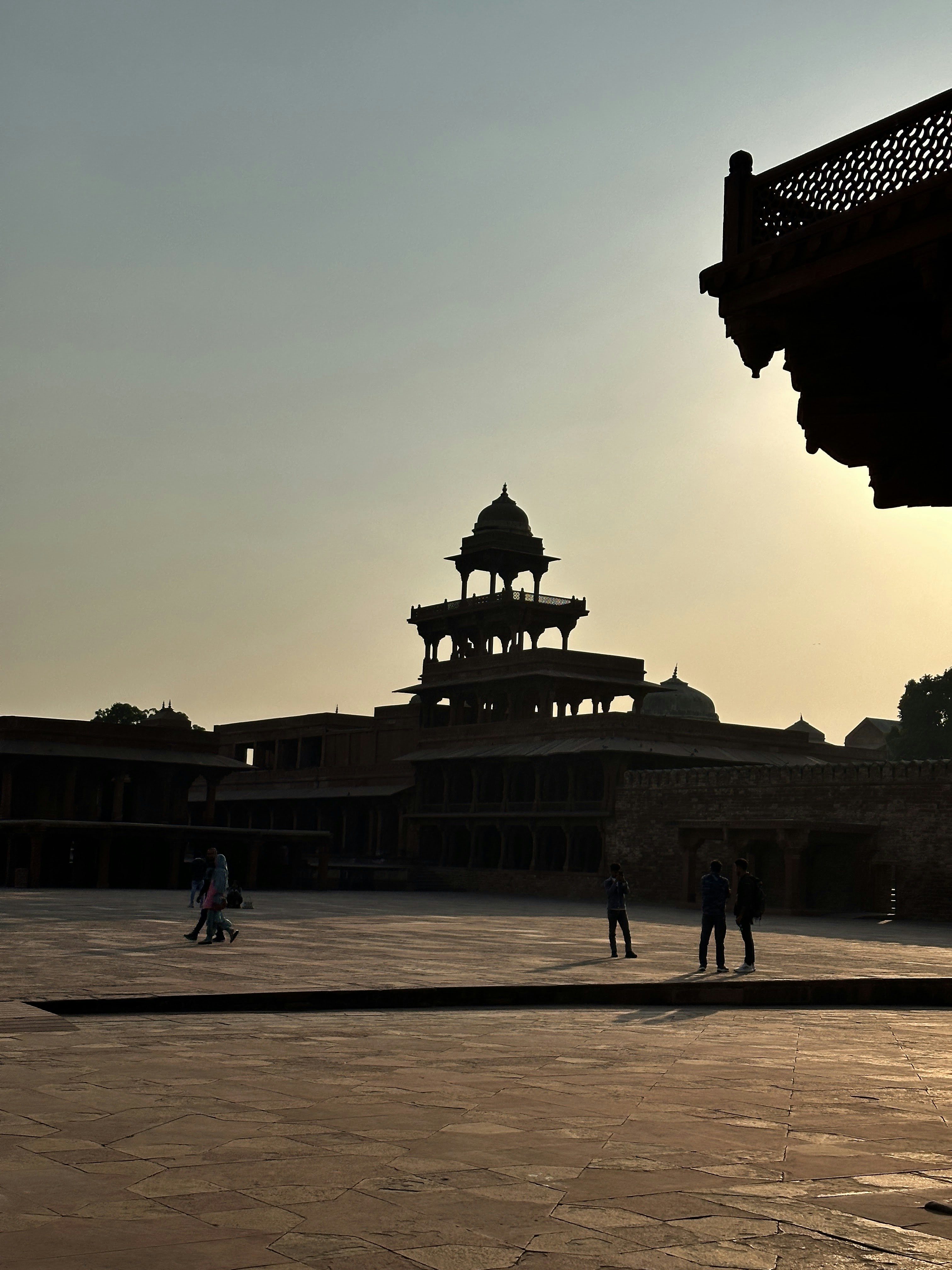 People in silhouette against the Panch Mahal at Fatehpur Sikri in India.