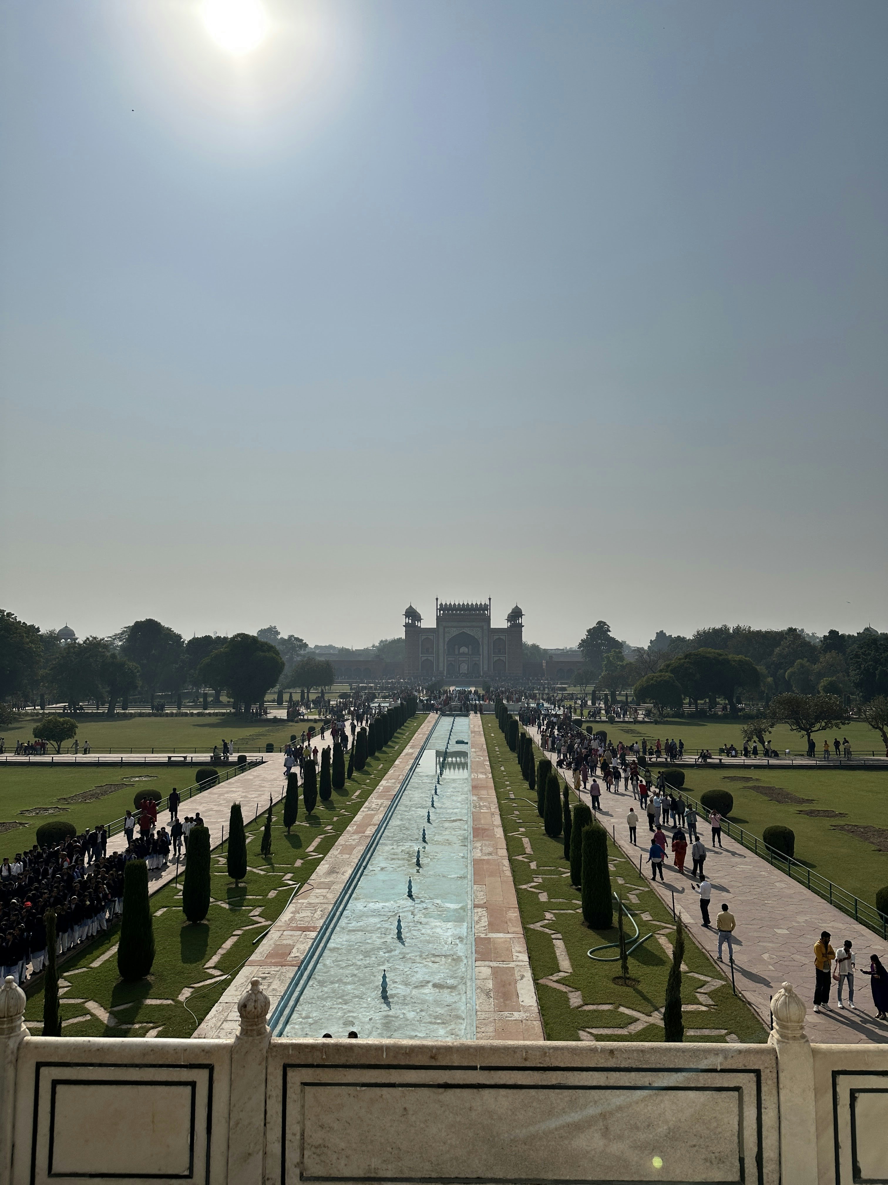 The Taj Mahal gate and gardens with a long reflecting pool in Agra, India.