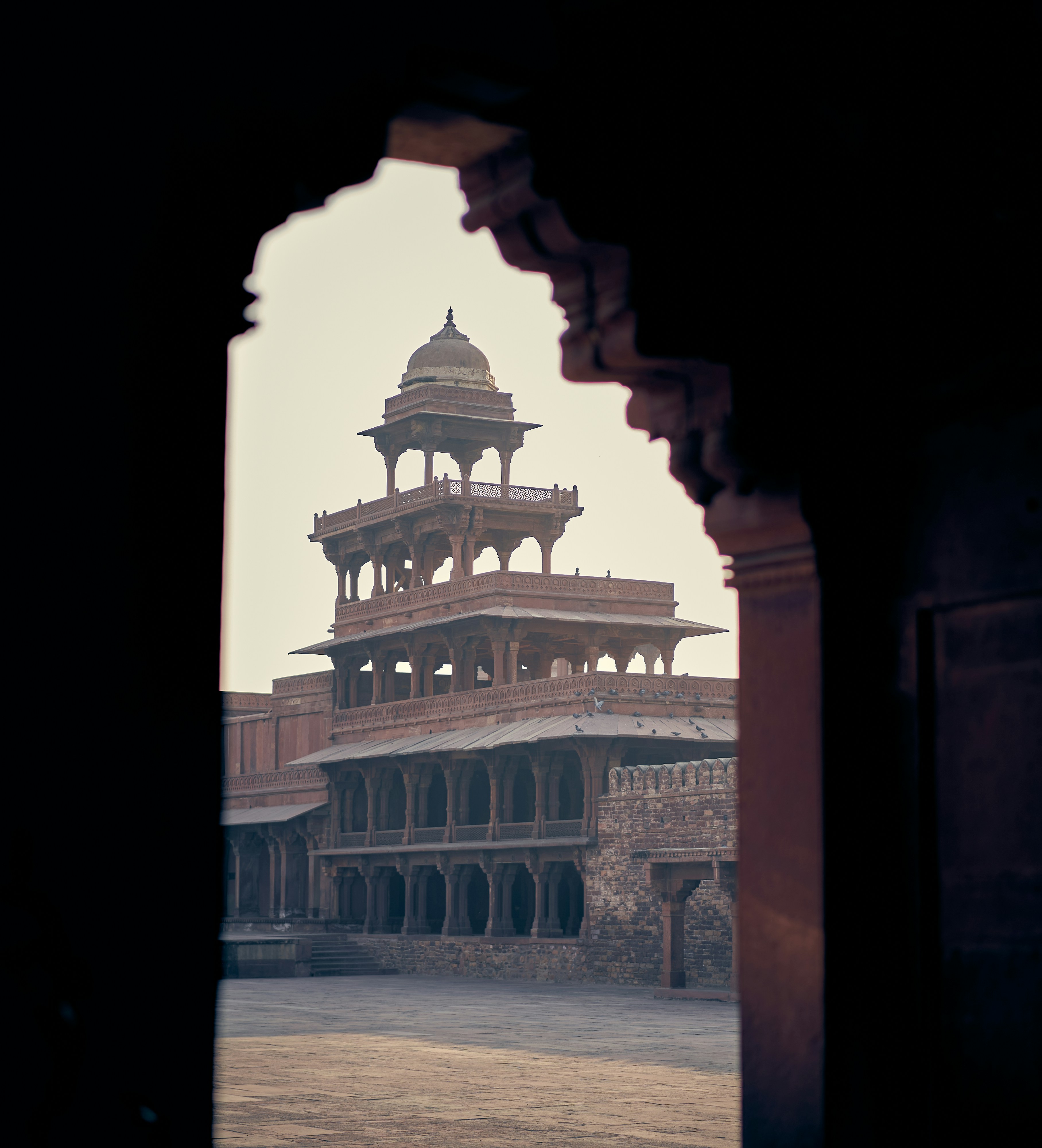 The Panch Mahal viewed through a stone archway in Fatehpur Sikri, India.