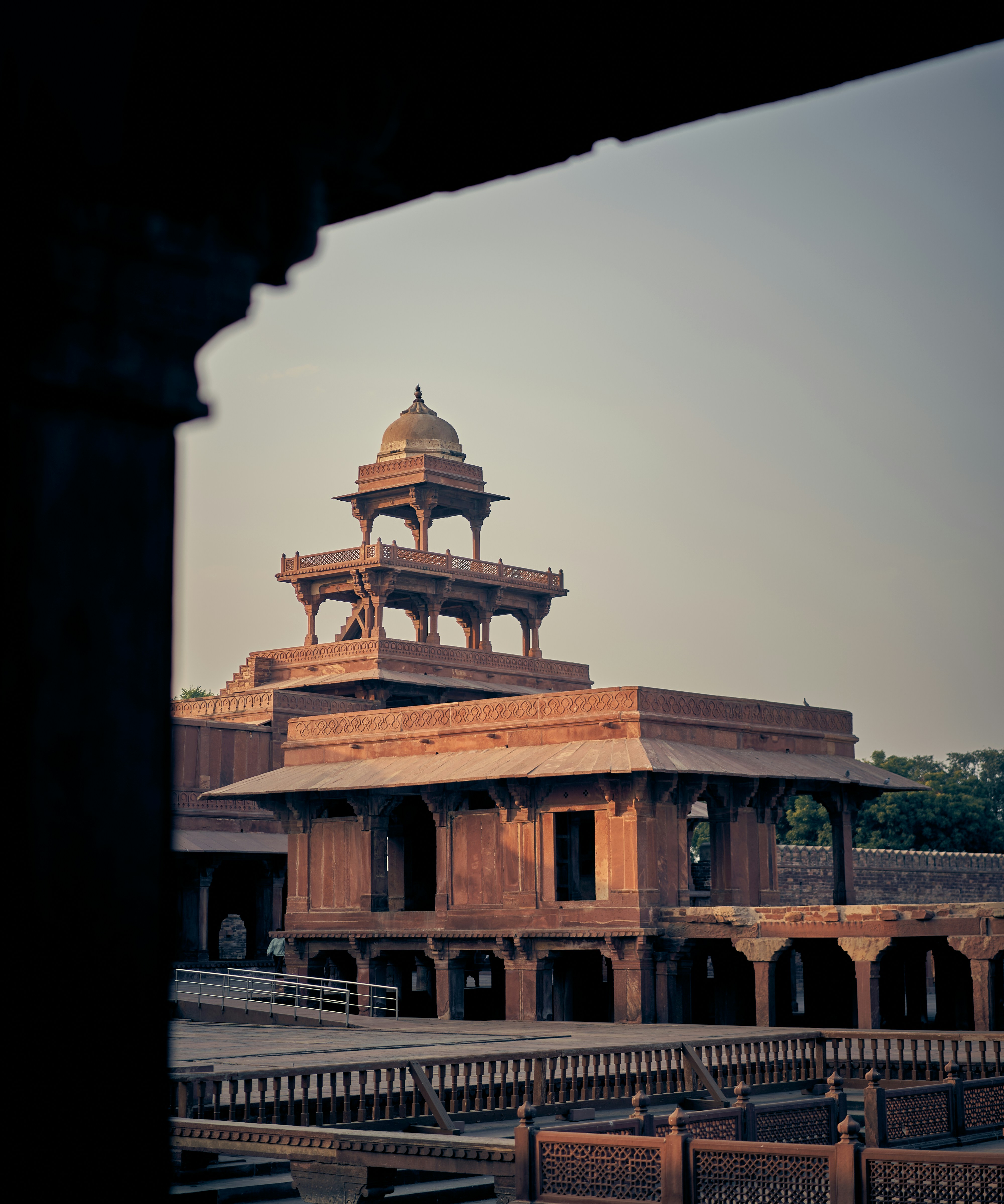 The Panch Mahal sandstone pavilion at Fatehpur Sikri, framed by a dark stone archway.