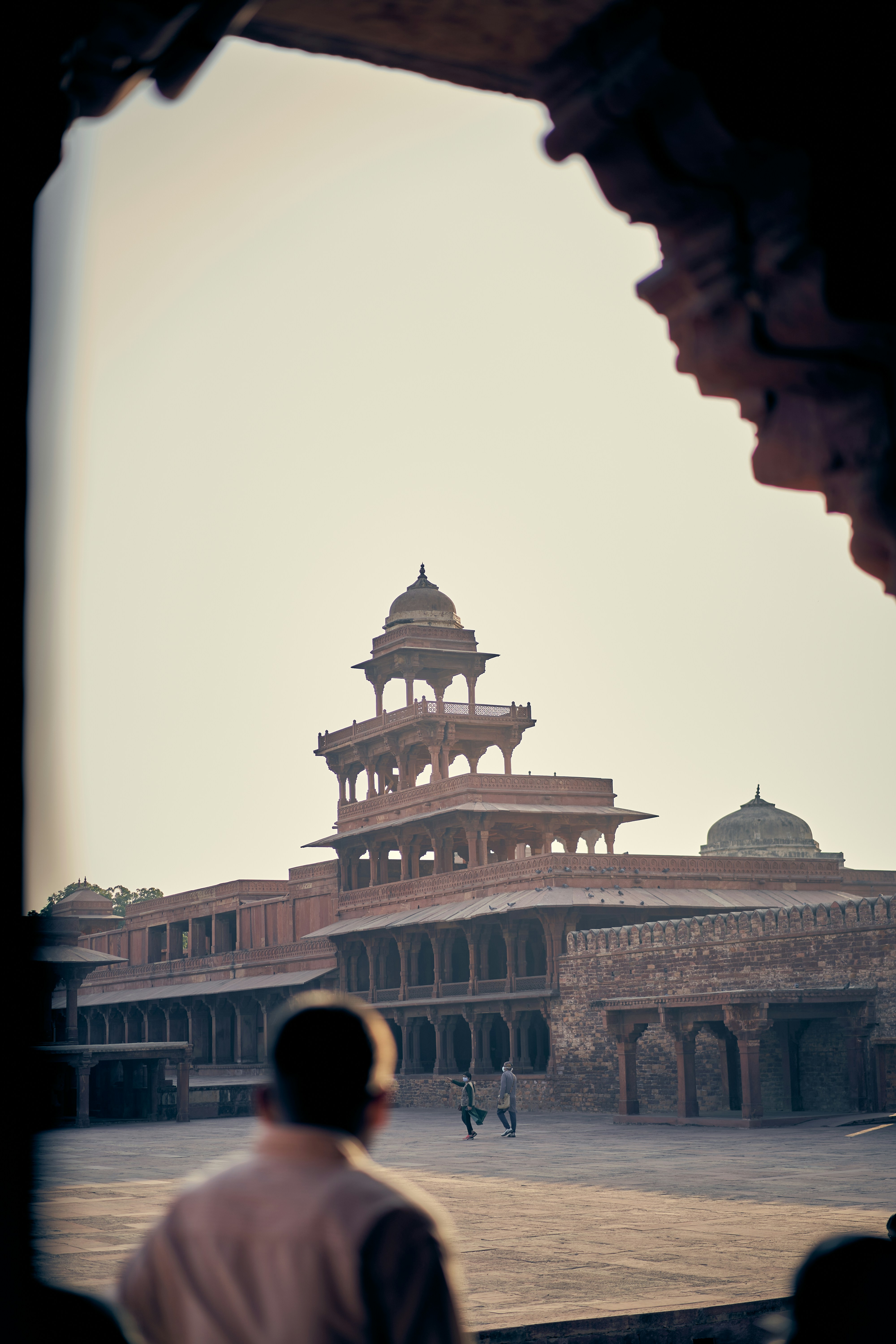 A person in silhouette looking toward the Panch Mahal in Fatehpur Sikri, India.