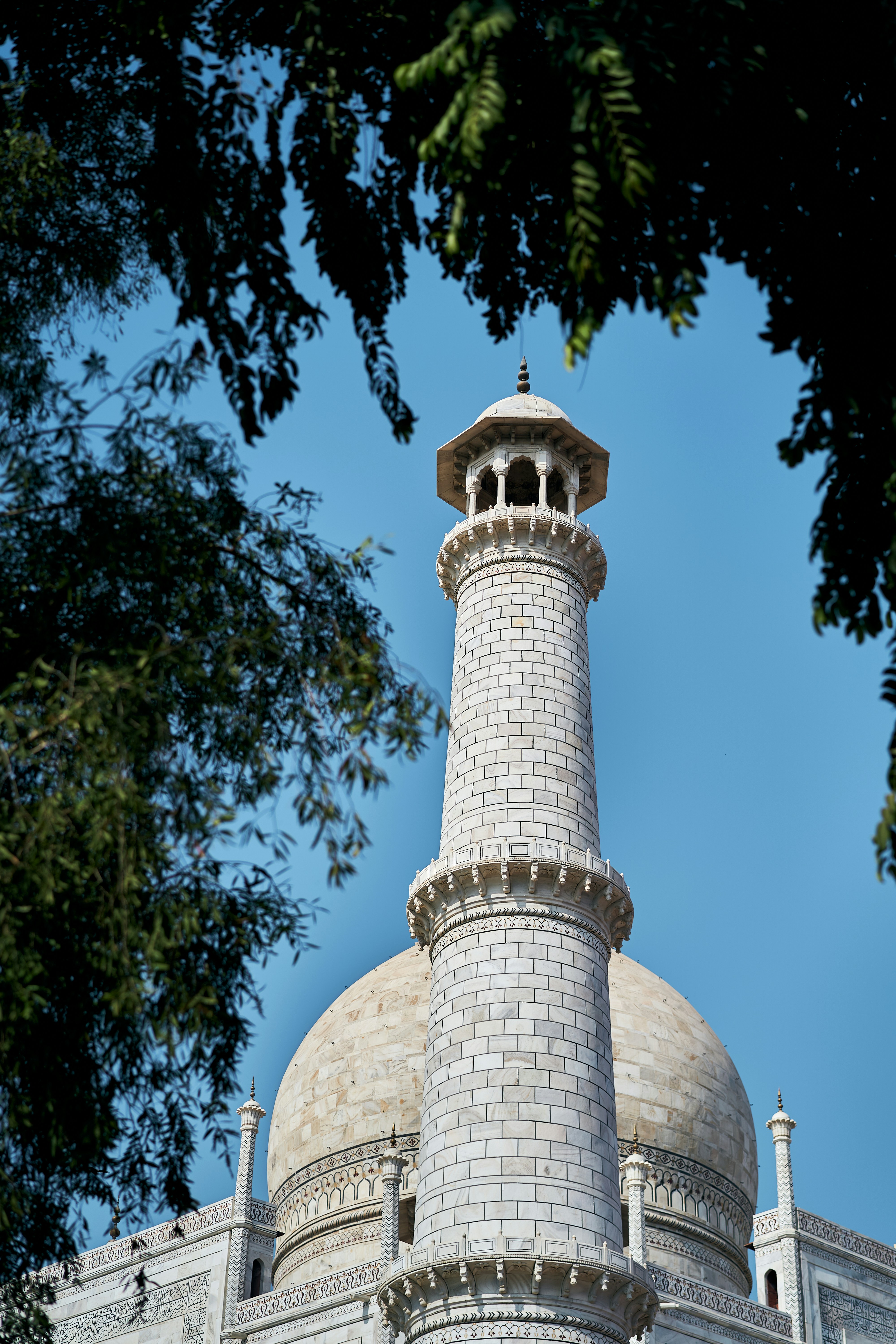 A white marble minaret and dome of the Taj Mahal in Agra, India.