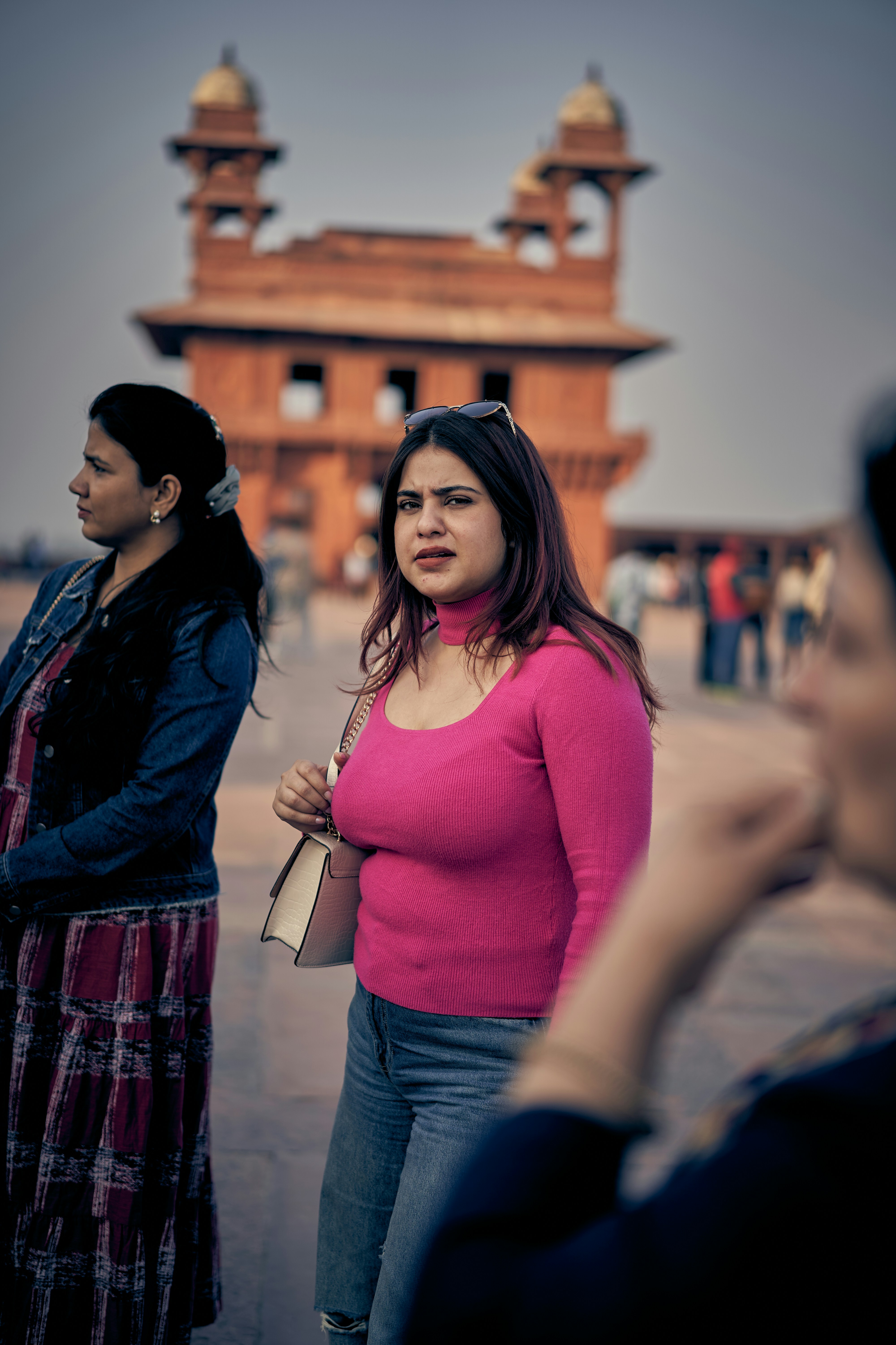 Two women in front of a red sandstone building at Fatehpur Sikri.