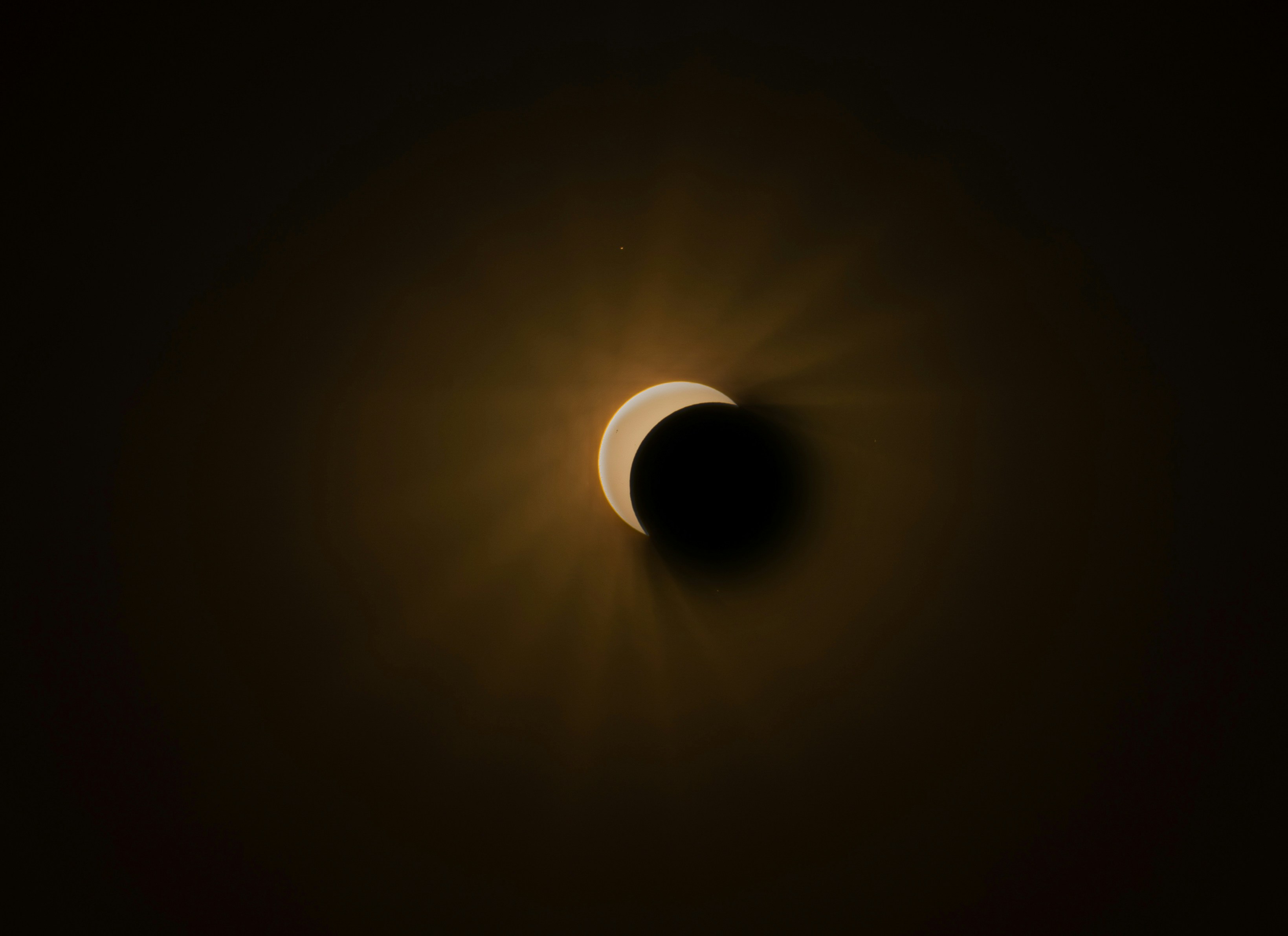 A partial solar eclipse with a glowing crescent against a dark sky