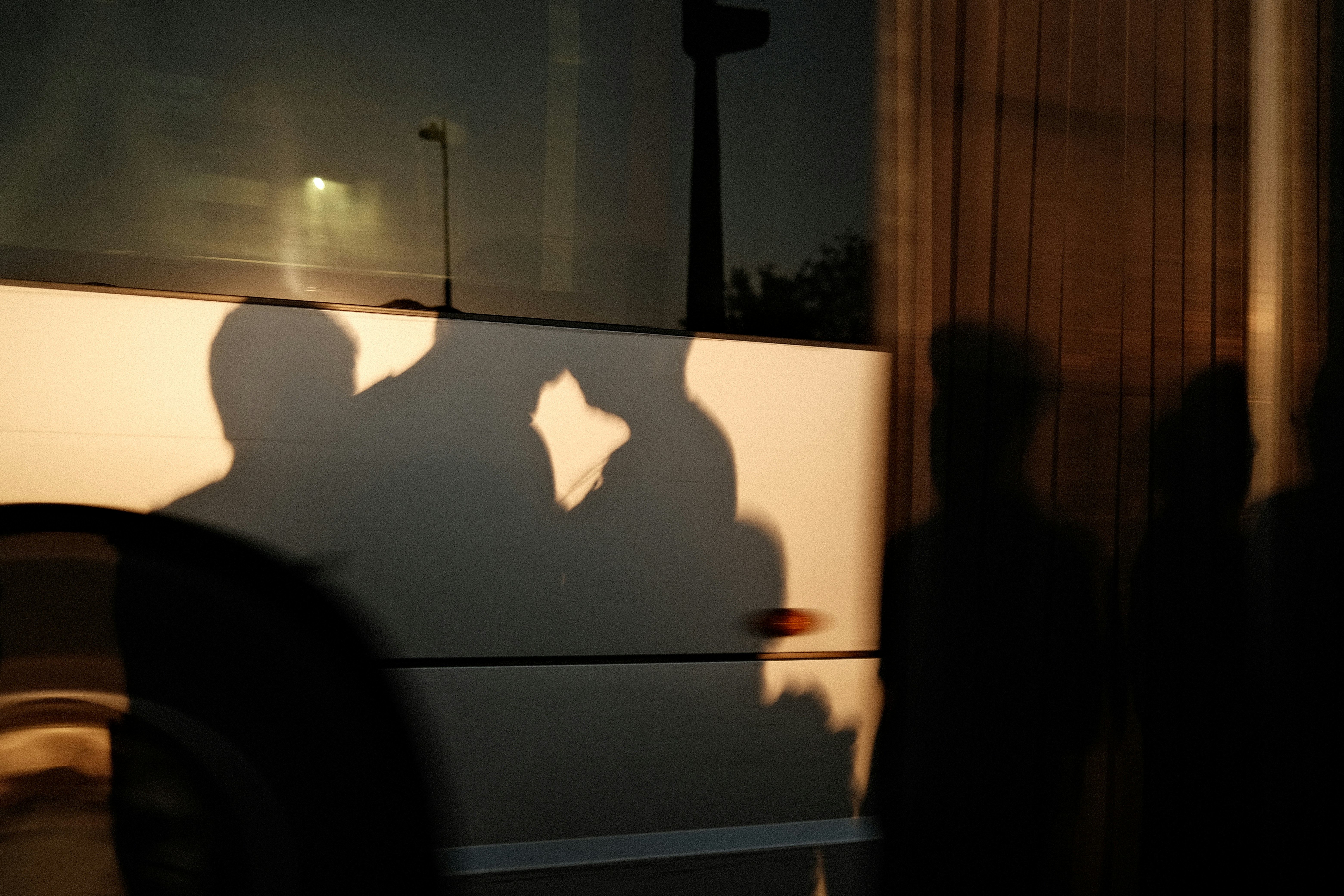 Silhouettes of people cast onto the side of a bus at night