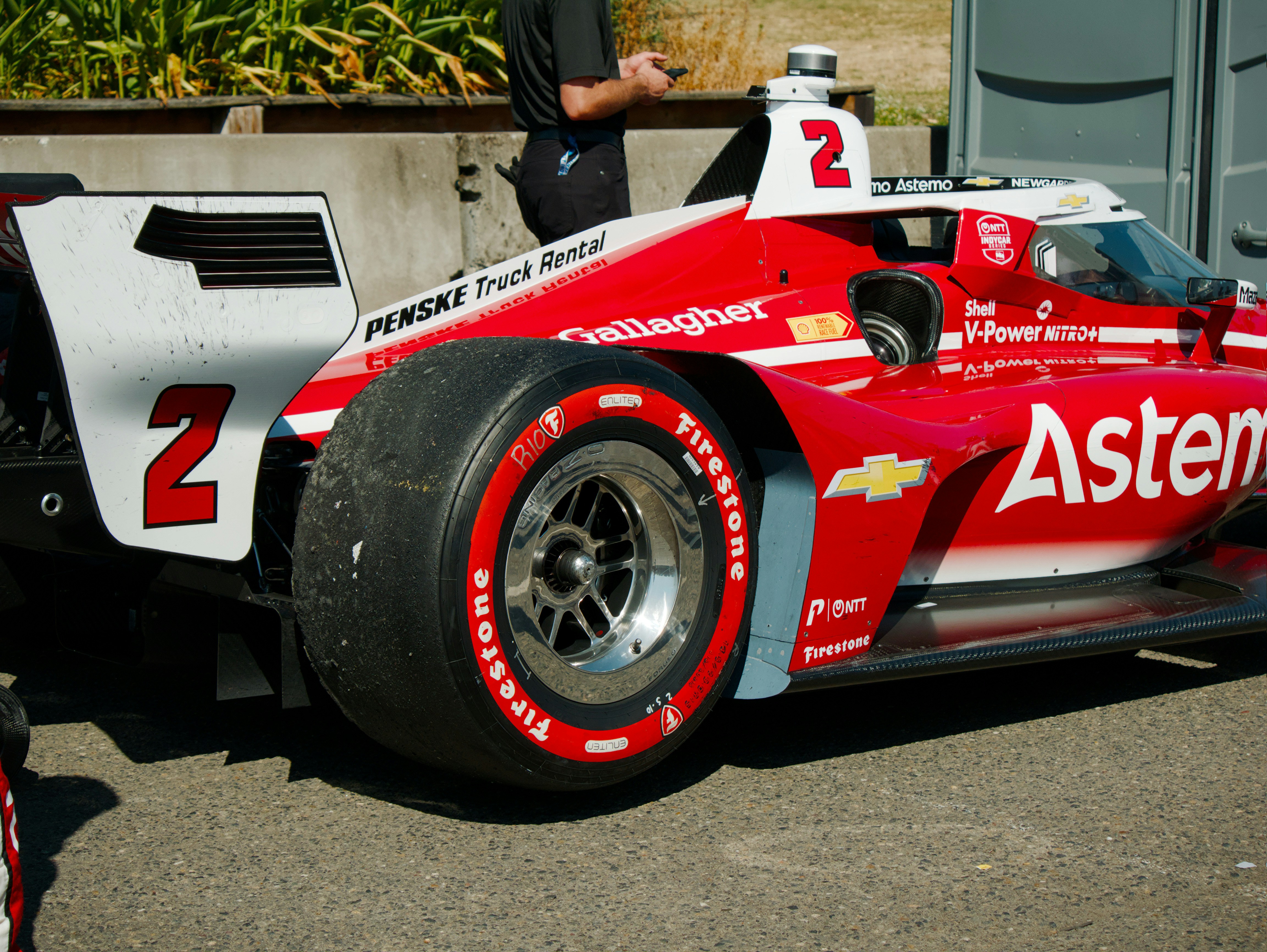 Un coche de carreras IndyCar rojo y blanco con el número dos en una pista