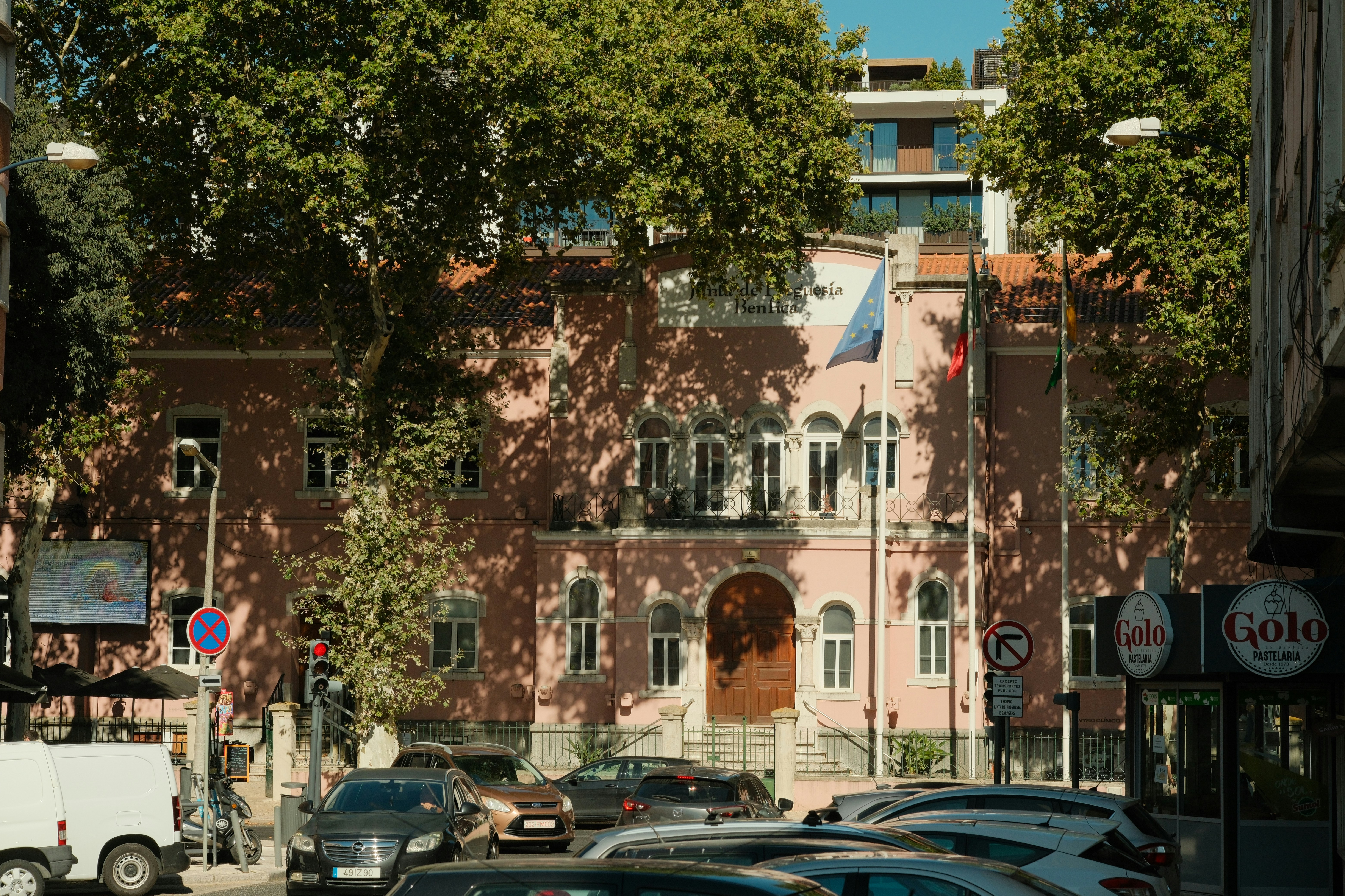 A pink building with arched windows and a wooden door in Lisbon, Portugal