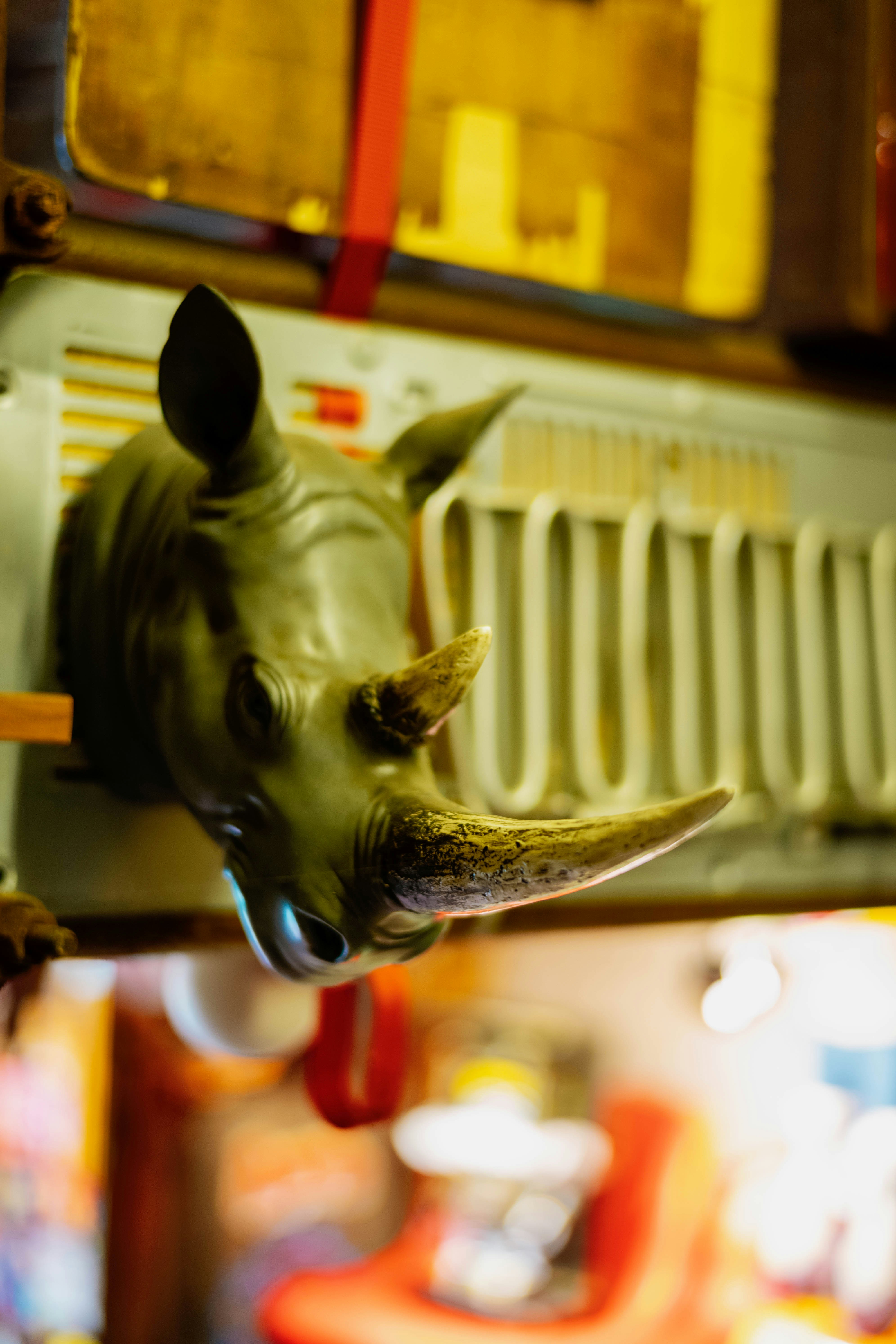 A rhinoceros head sculpture mounted on a metal radiator in a dimly lit room.