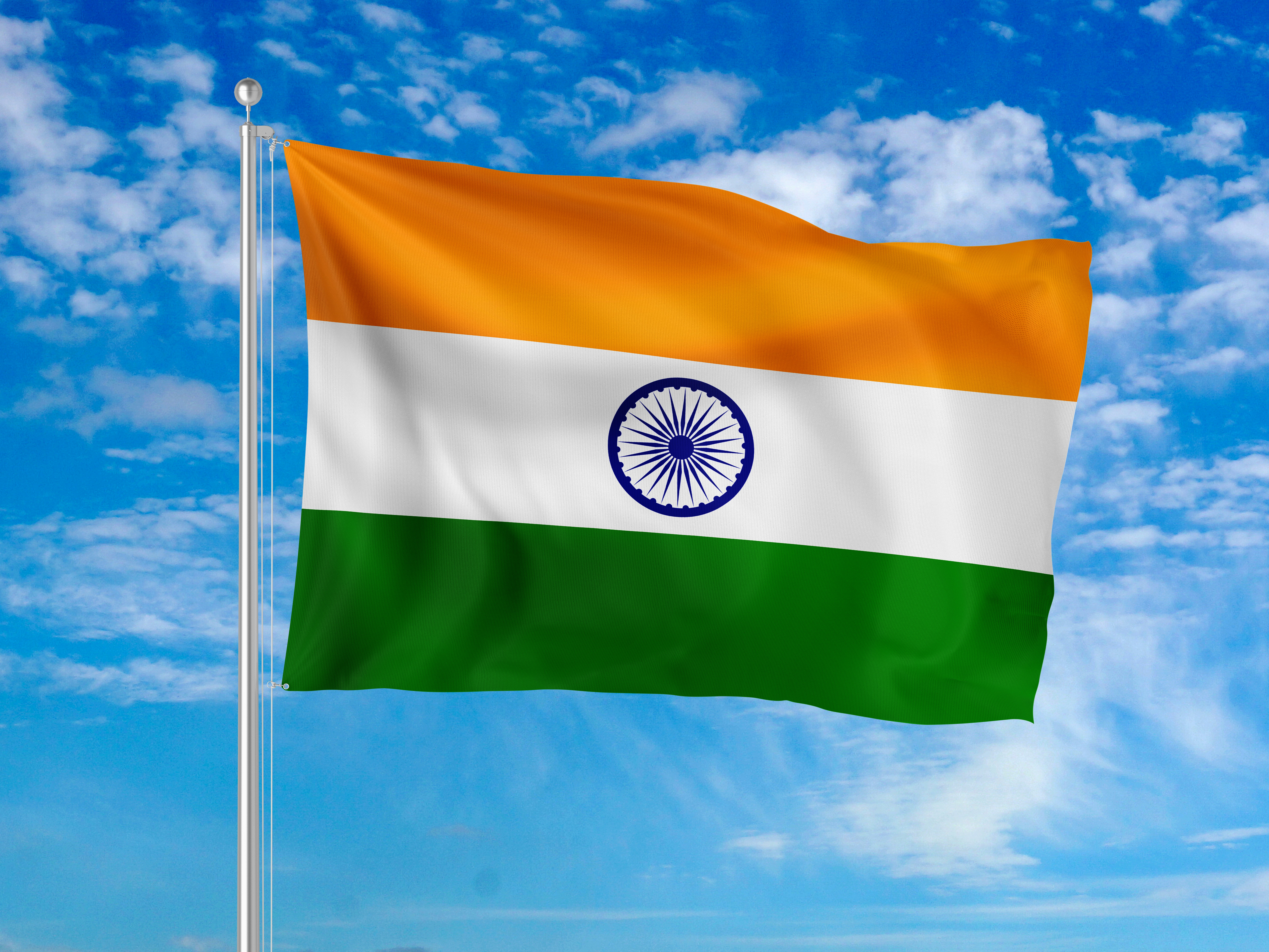 Die Nationalflagge Indiens weht an einer Metallstange gegen einen blauen Himmel