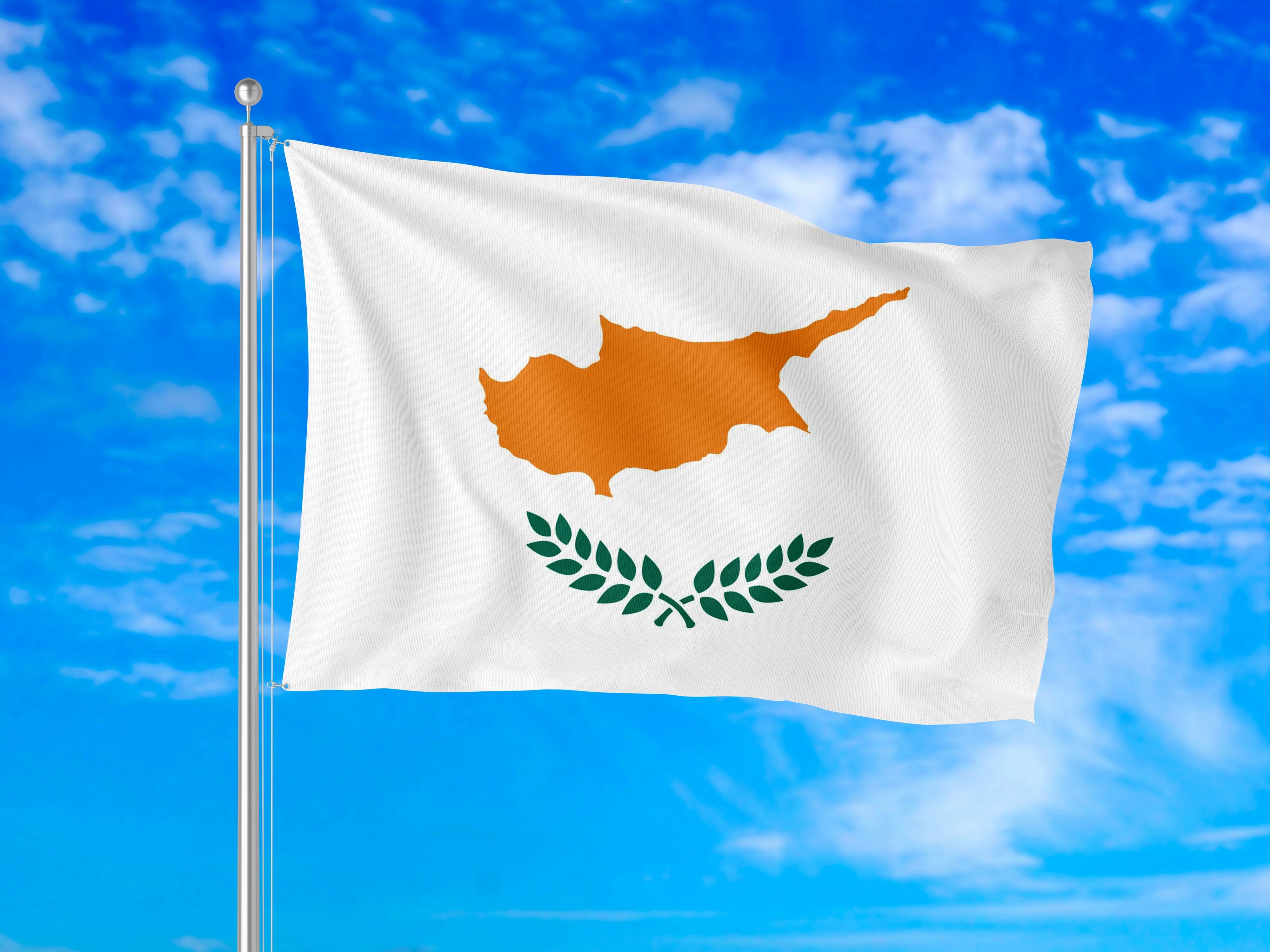 The national flag of Cyprus waving against a bright blue sky with clouds