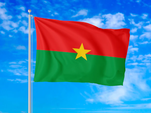 The flag of Burkina Faso waving against a blue sky