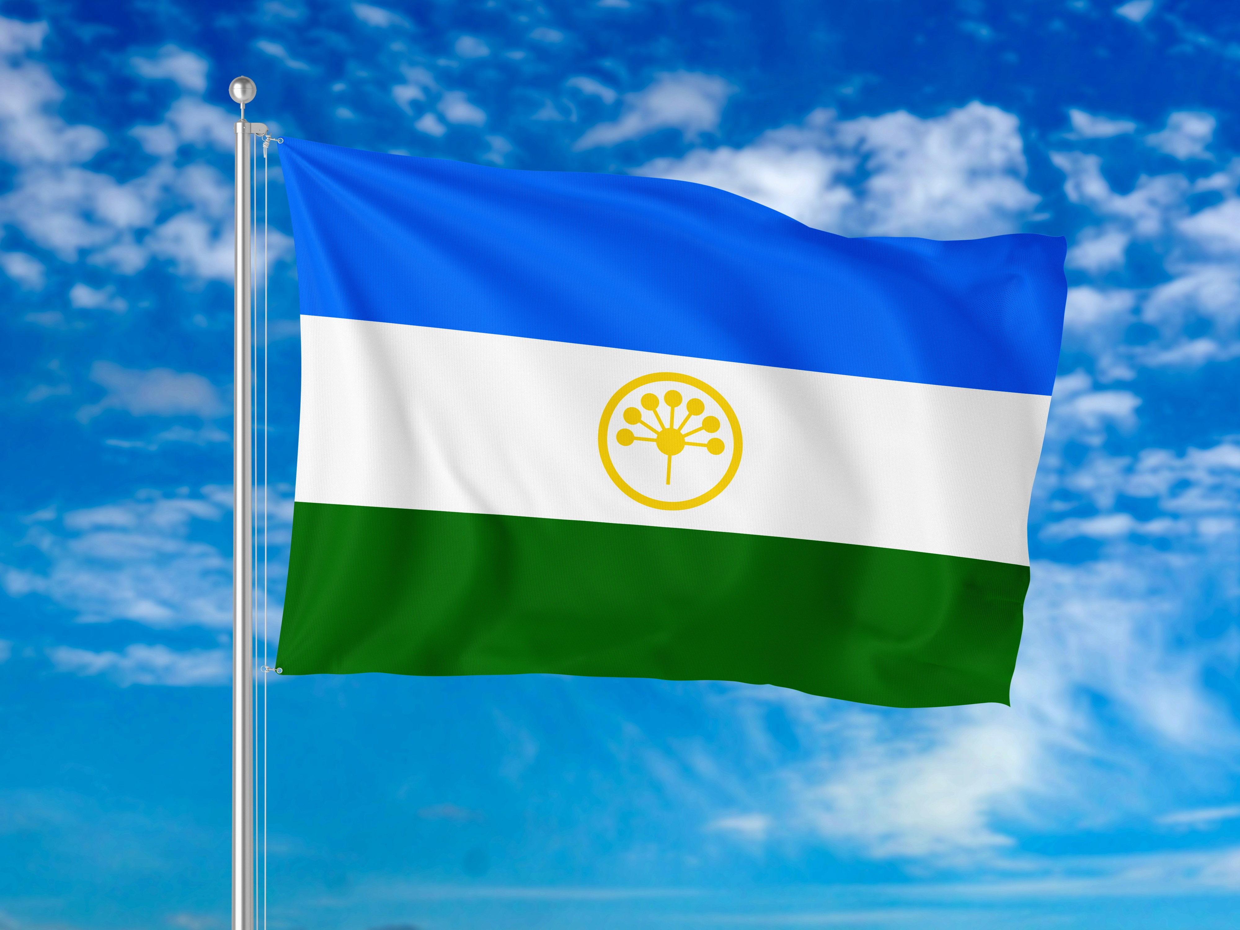 Bendera Bashkortostan berkibar di tiang melawan langit biru