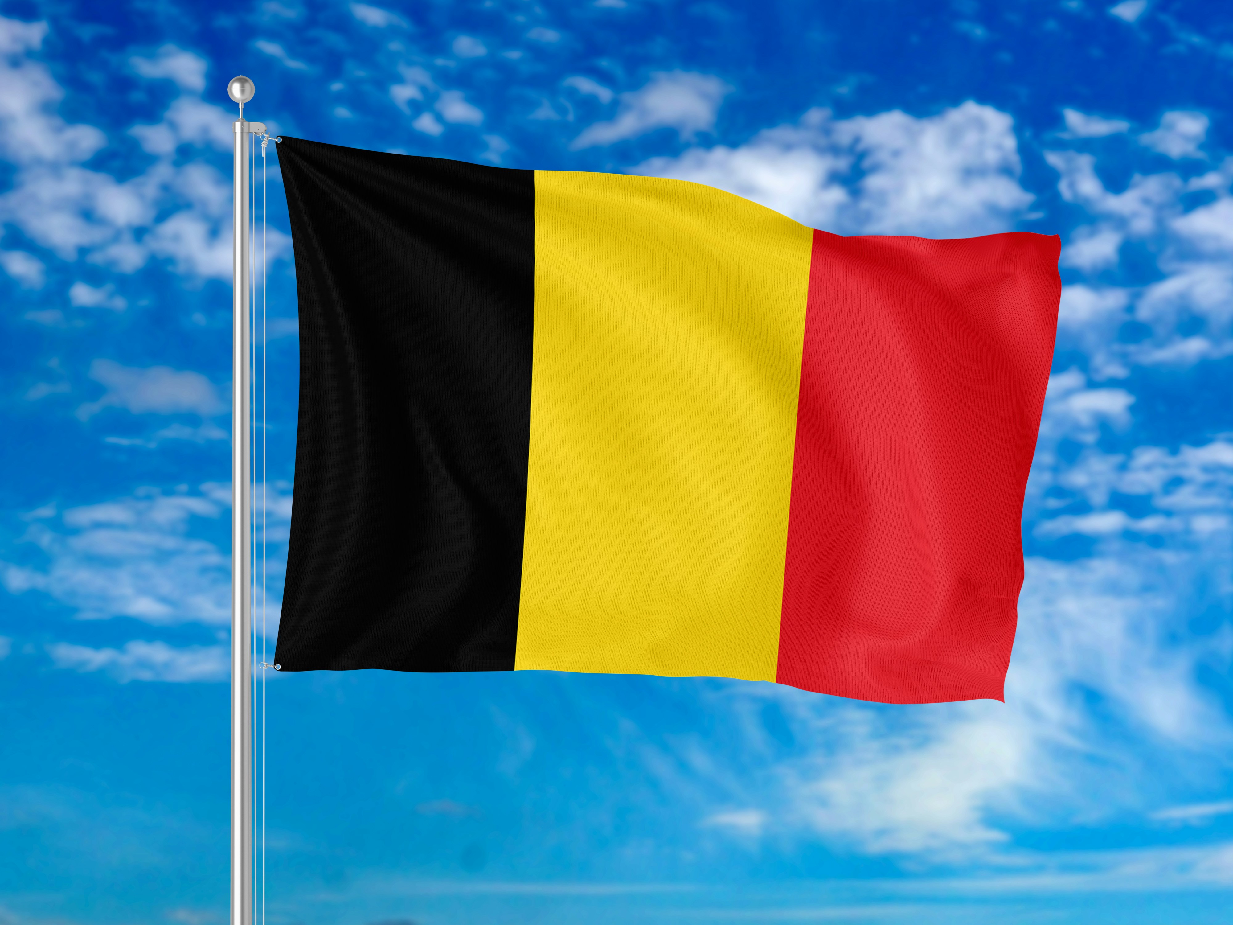 Drapeau belge flottant sur son mât sous un ciel bleu, en pleine négociation du budget fédéral d'octobre 2026 (photo d'illustration)