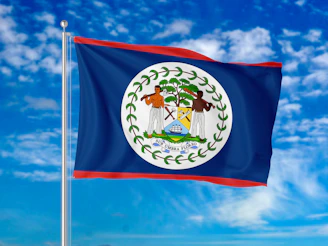 The national flag of Belize waving against a bright blue sky with clouds NO women on the flag.