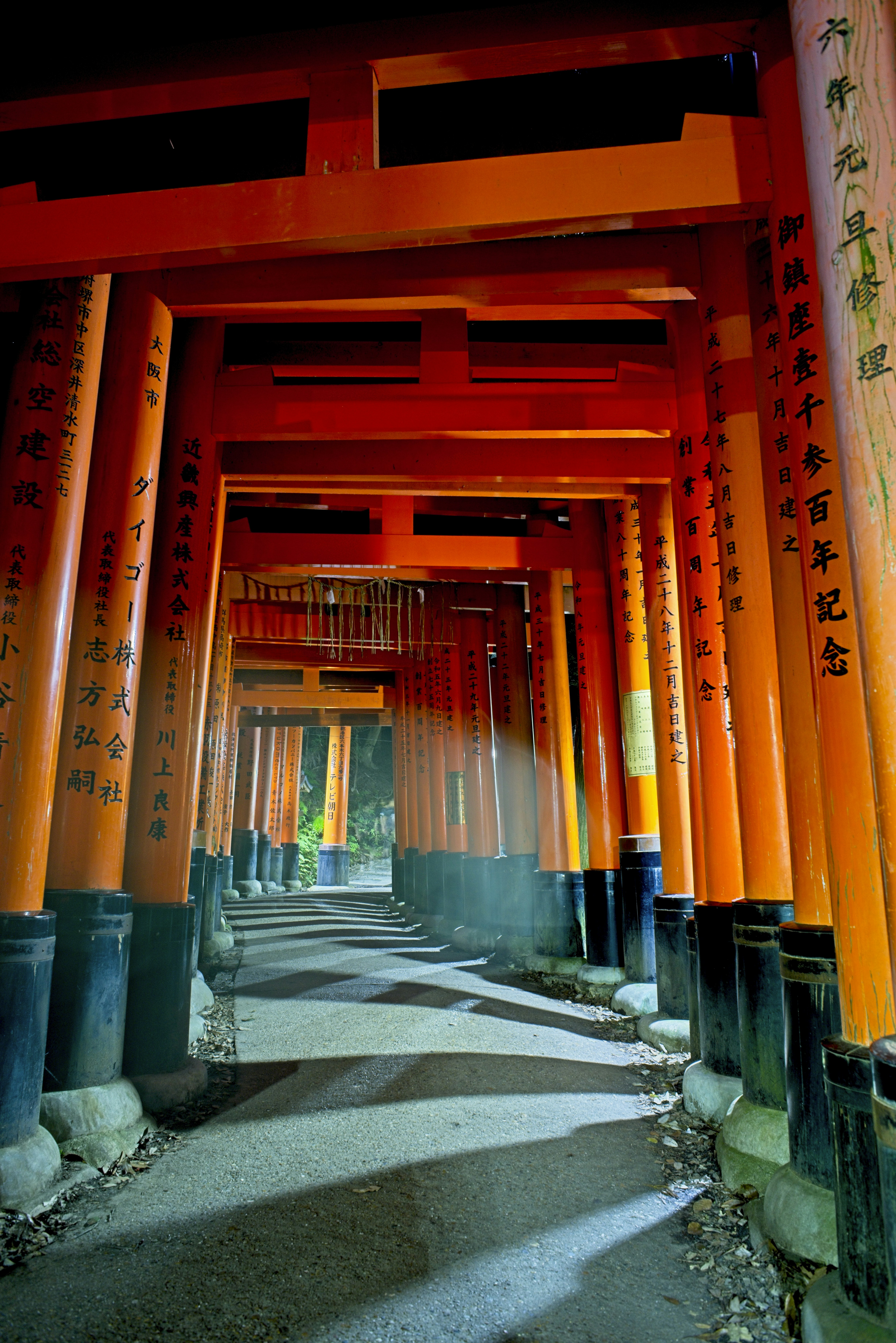 Un camino entre filas de torii naranja brillante en el Santuario Fushimi Inari en Kioto.