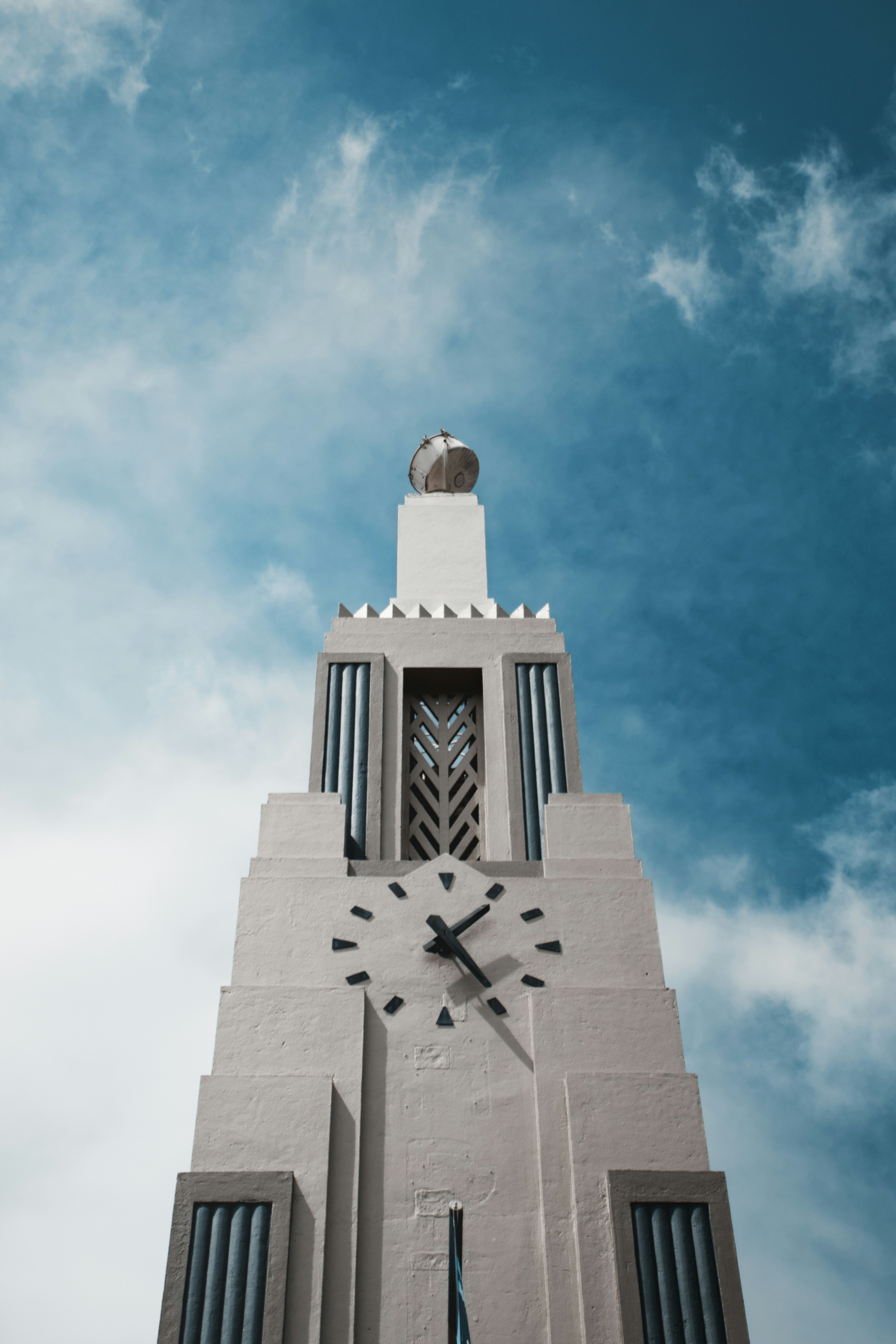 Une vue basse d’une tour d’horloge art déco sur un ciel bleu