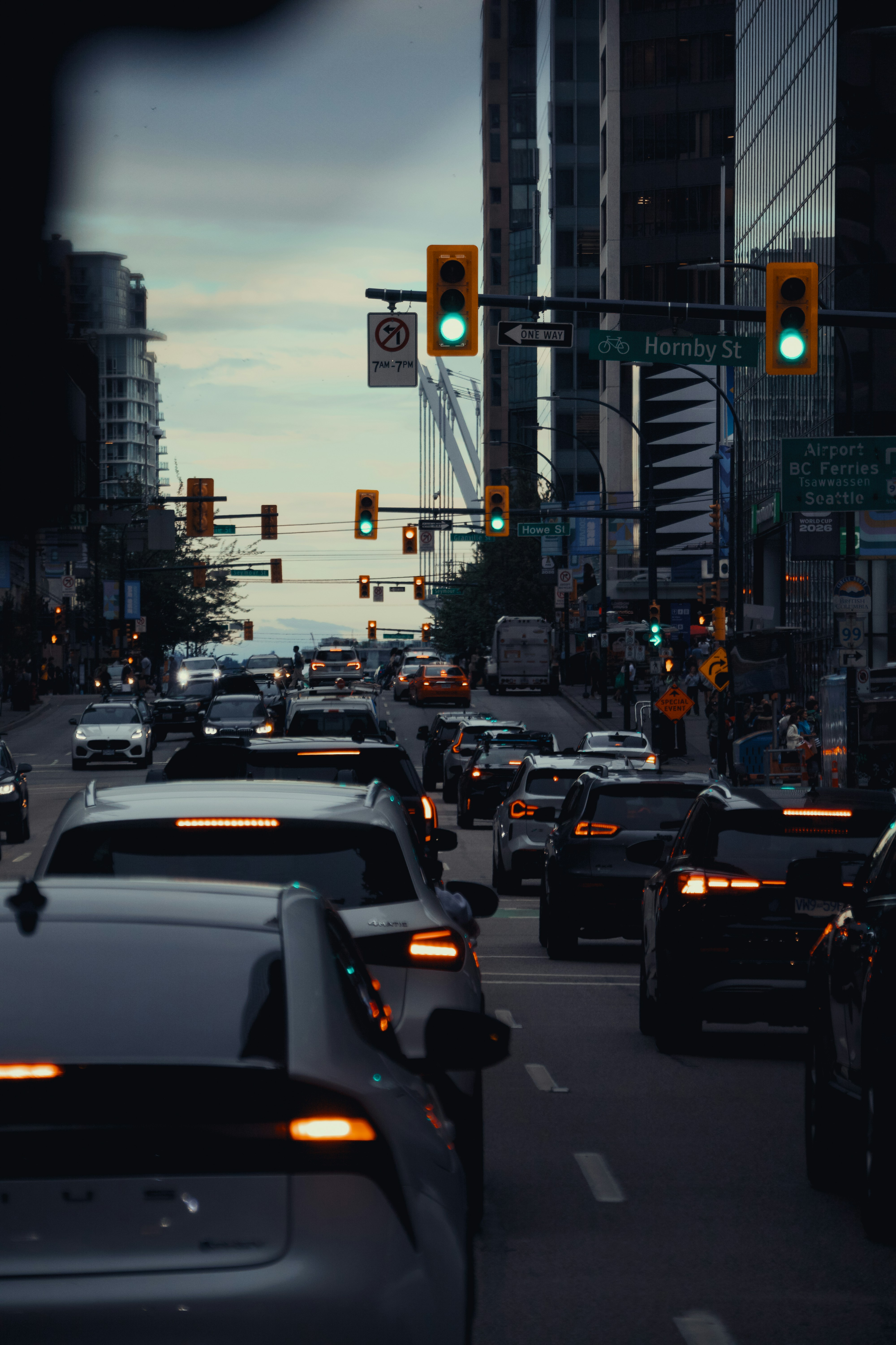 La circulation sur la rue Hornby à Vancouver avec des feux verts et des gratte-ciel en ville