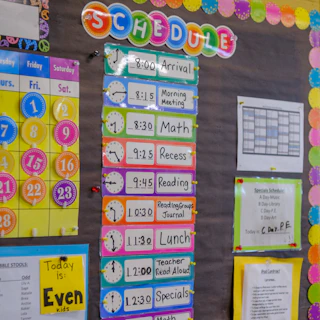 A colorful classroom schedule board with clock icons and daily activity labels