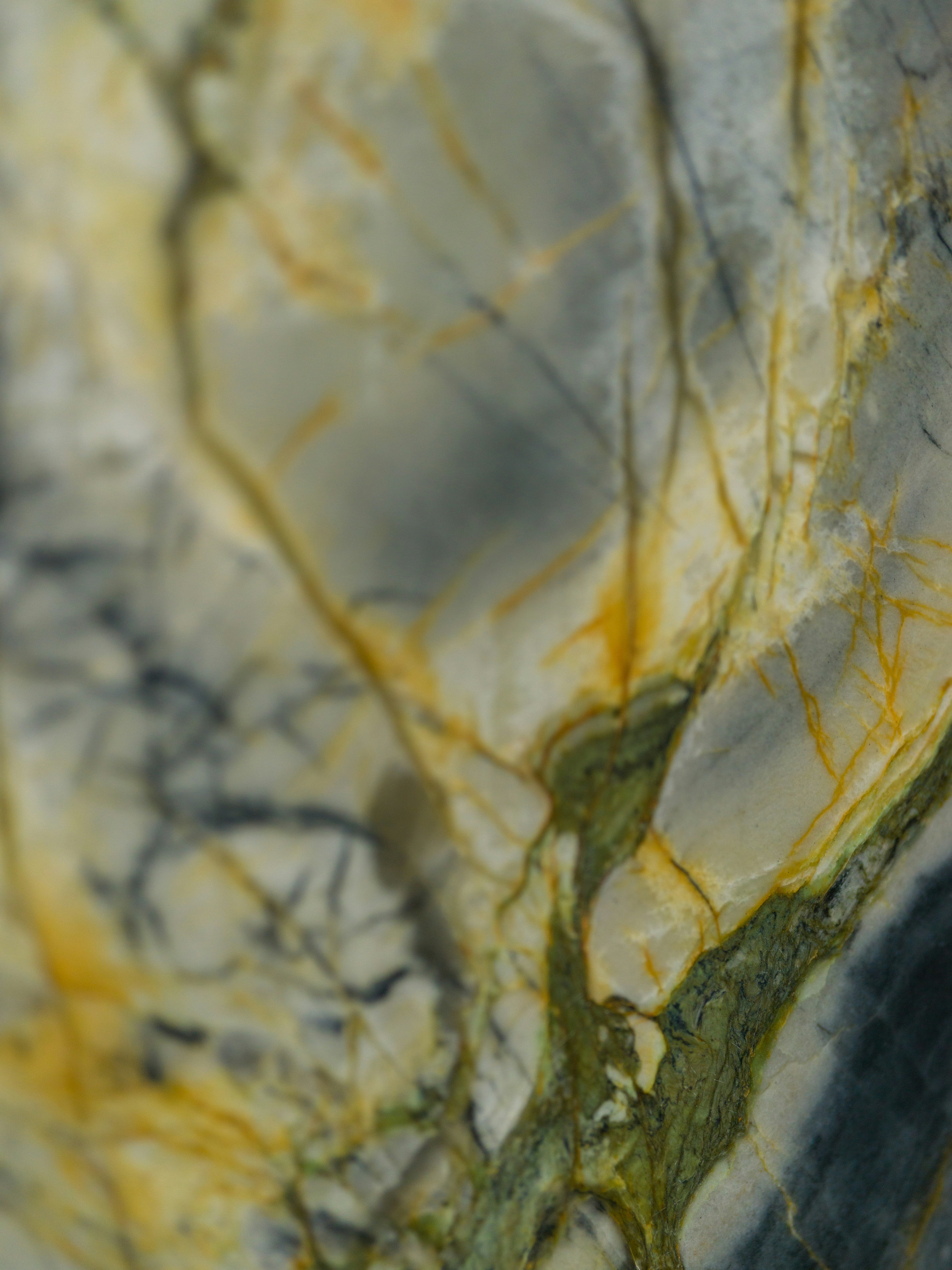 Close-up of polished marble with grey, green, and yellow veining