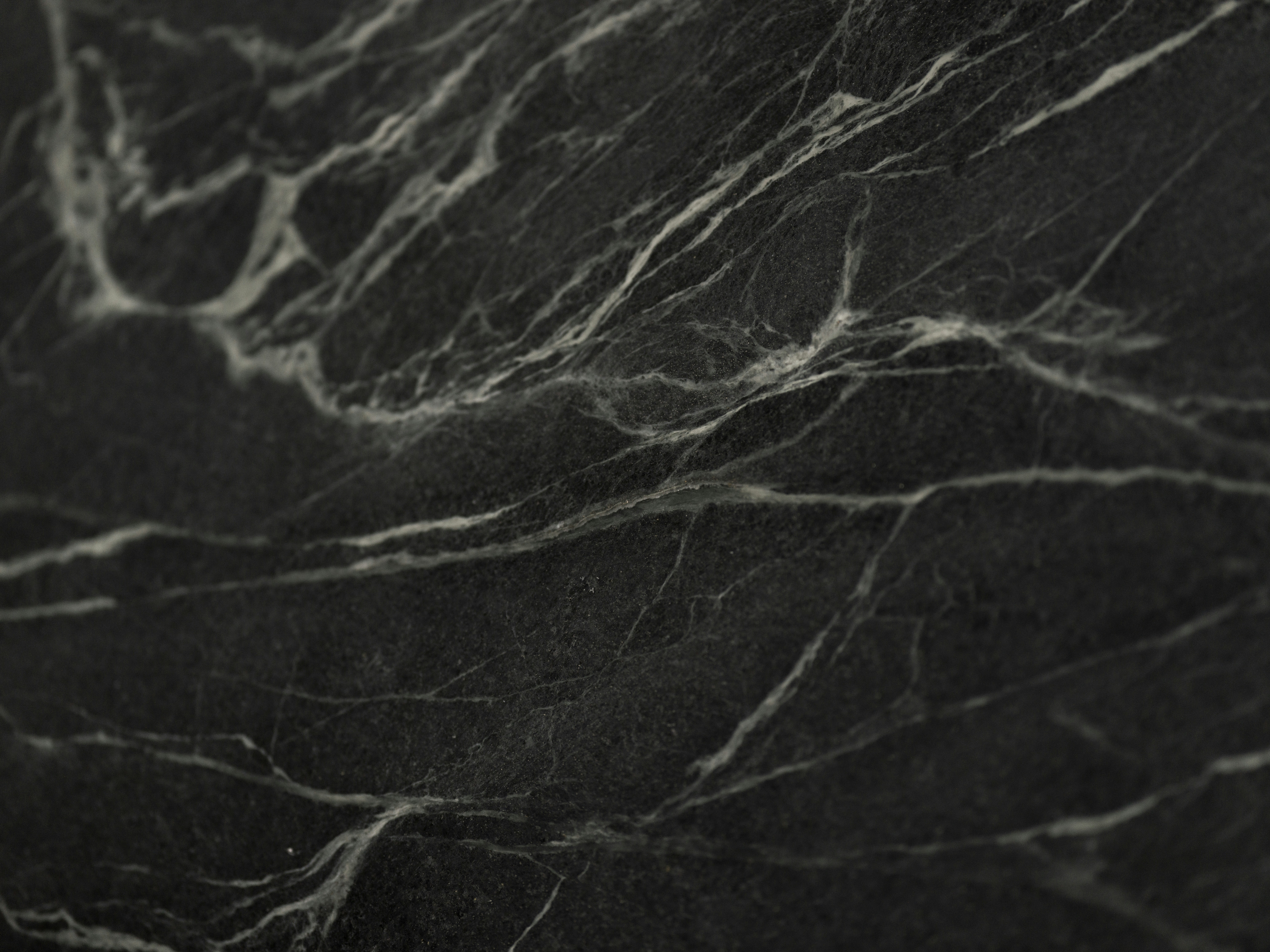 A dark black marble surface with intricate white veining patterns