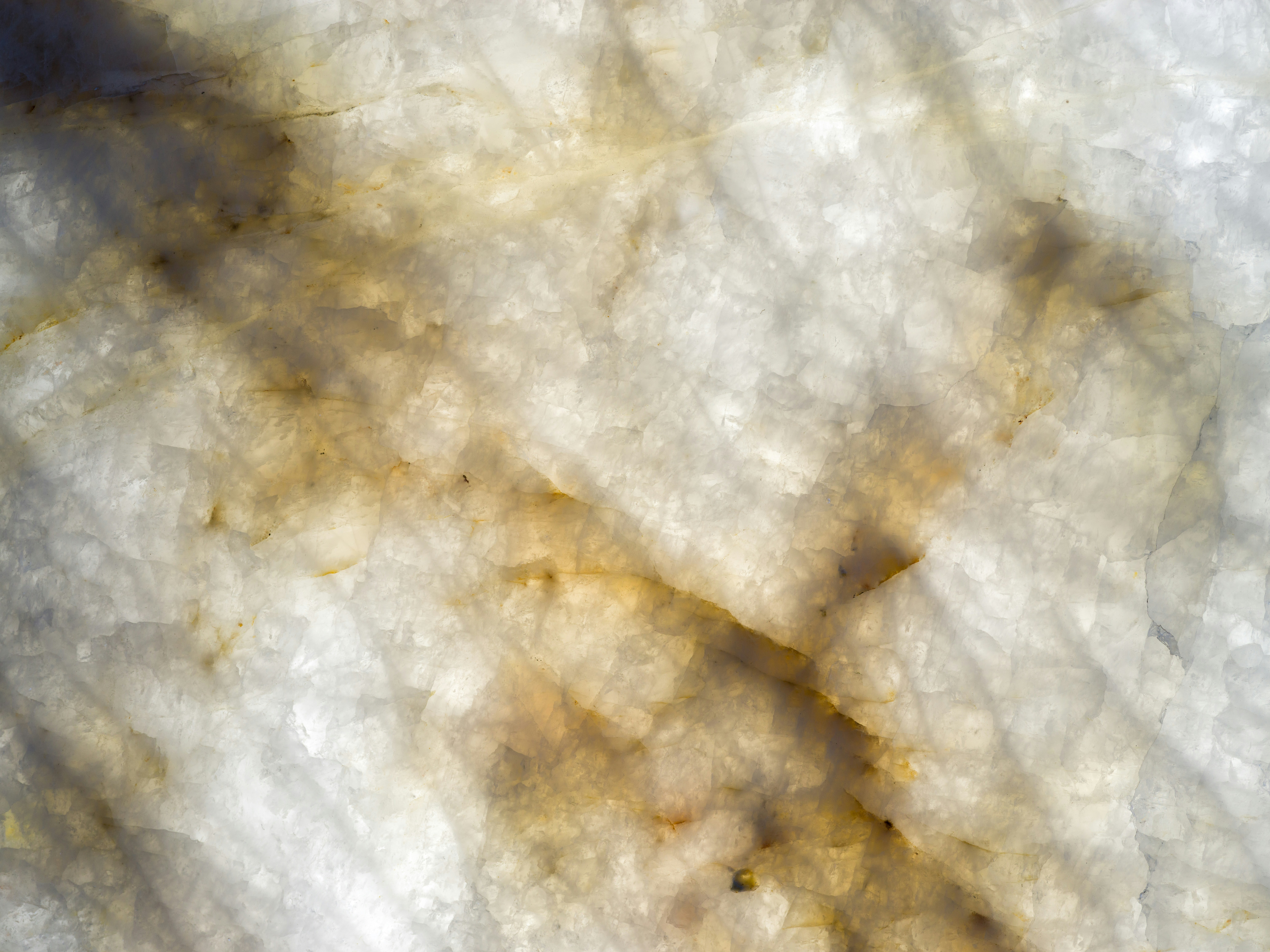 Translucent white quartz slab with golden brown veining and crystalline texture