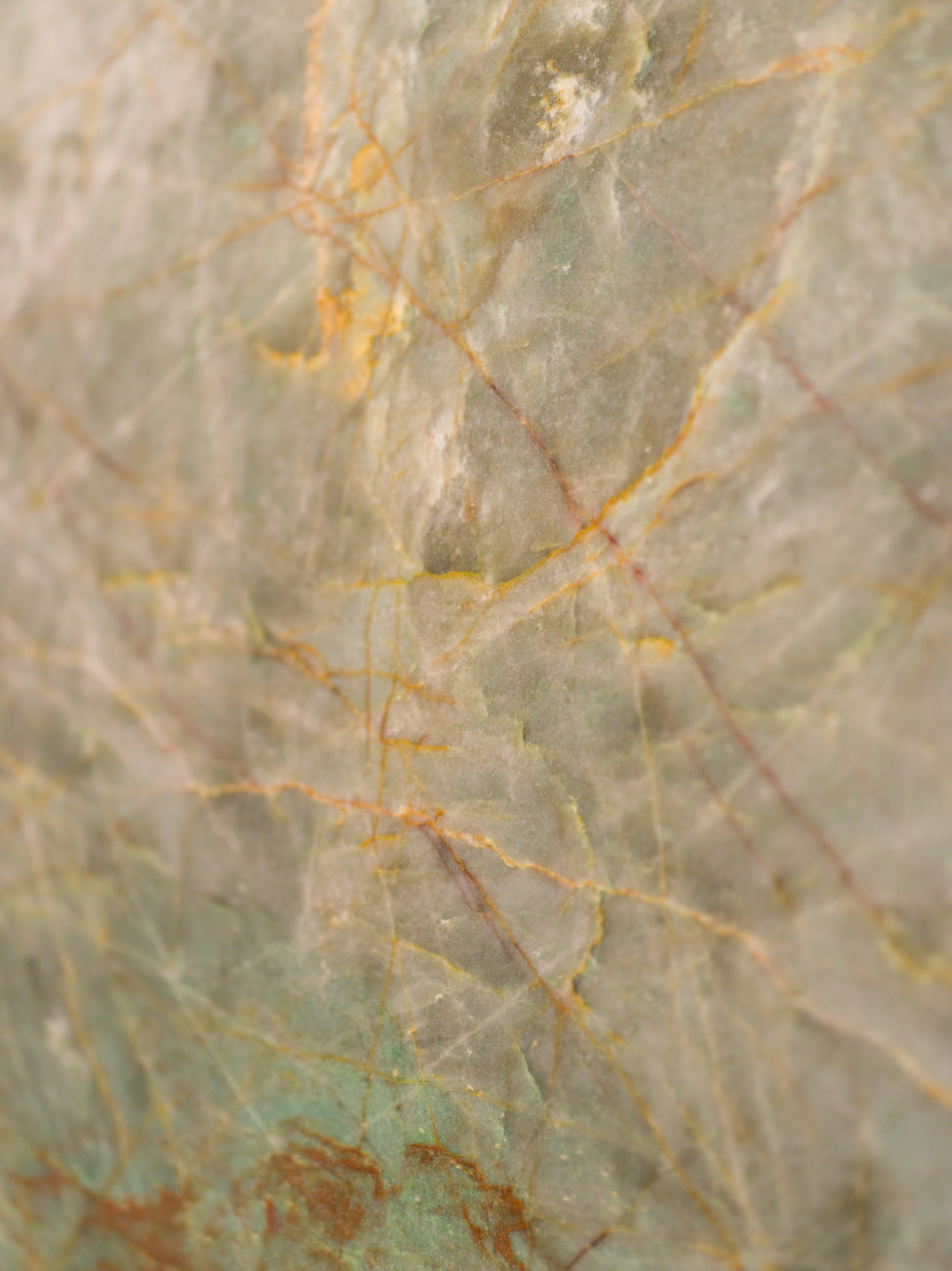 A polished green marble slab with intricate orange and brown veining