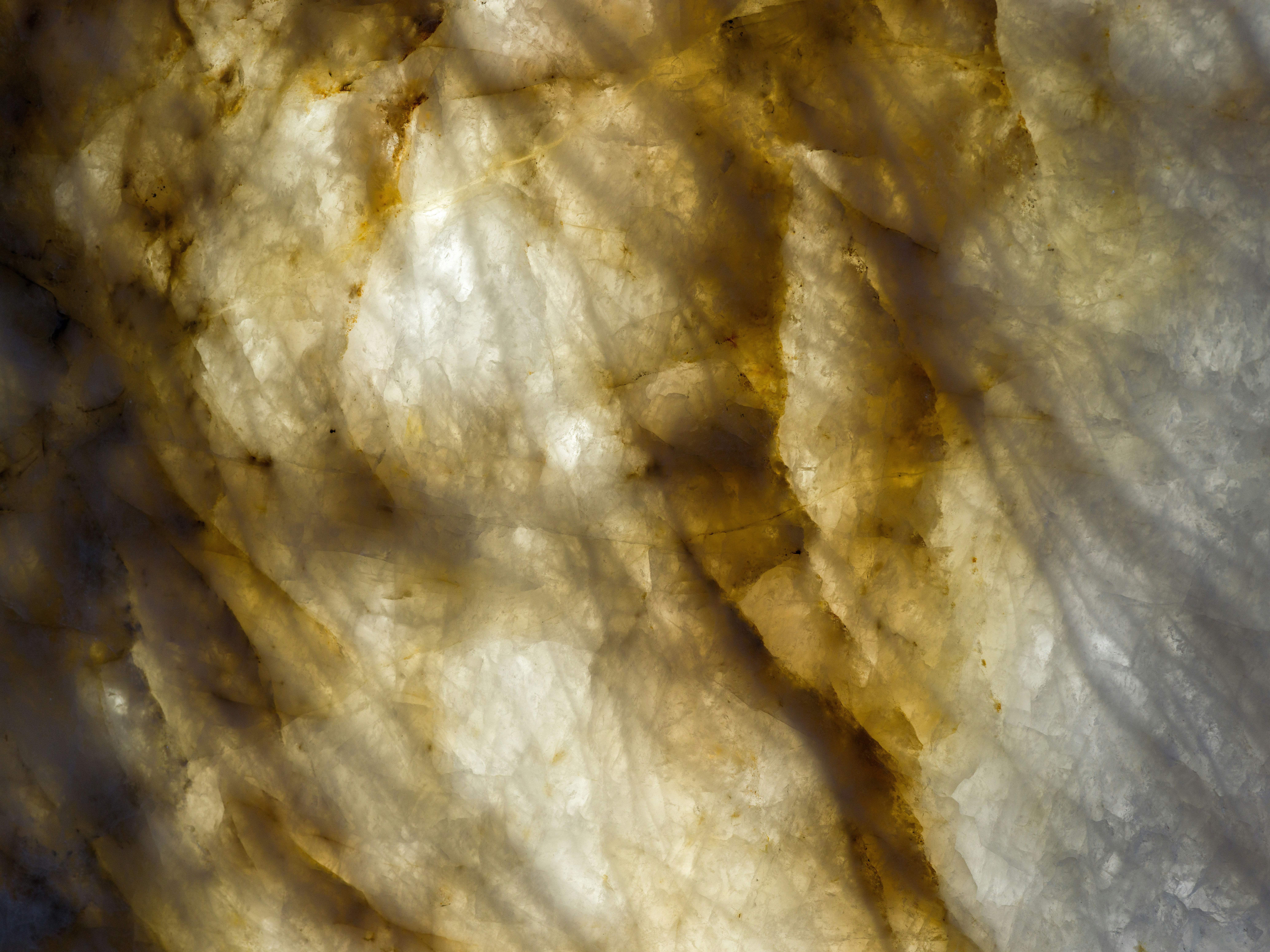 Backlit translucent stone slab with golden veins and crystalline texture