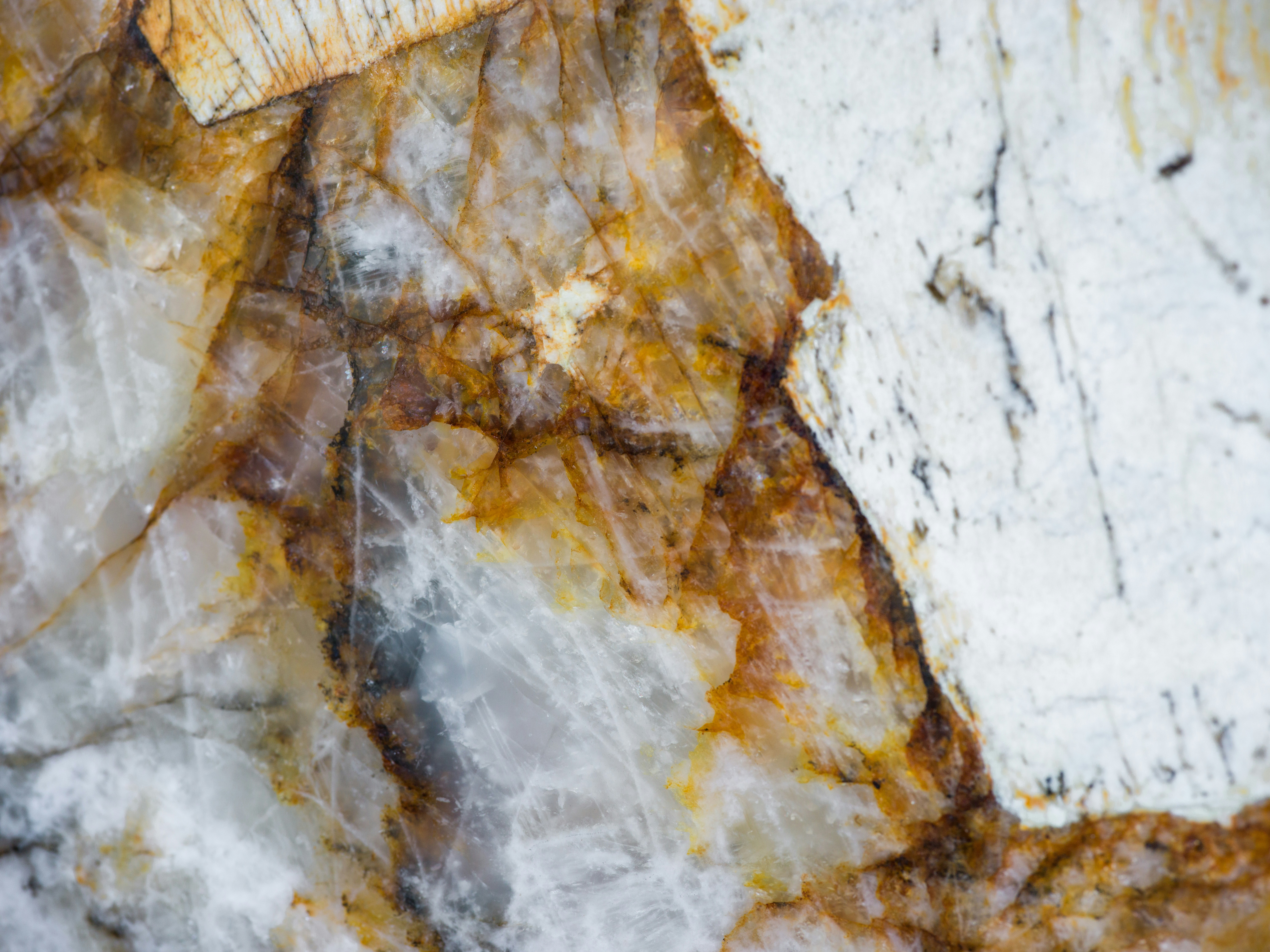 A close-up of white and orange marble with intricate brown veining