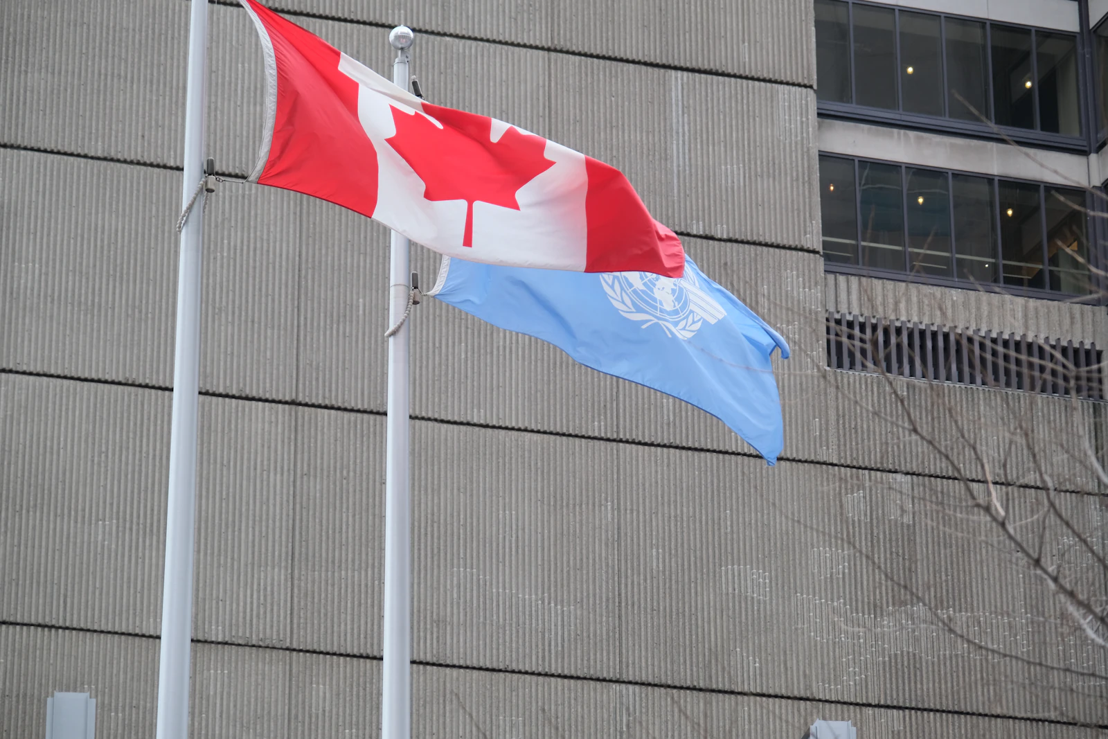 Canadian and United Nations flags outside an international building