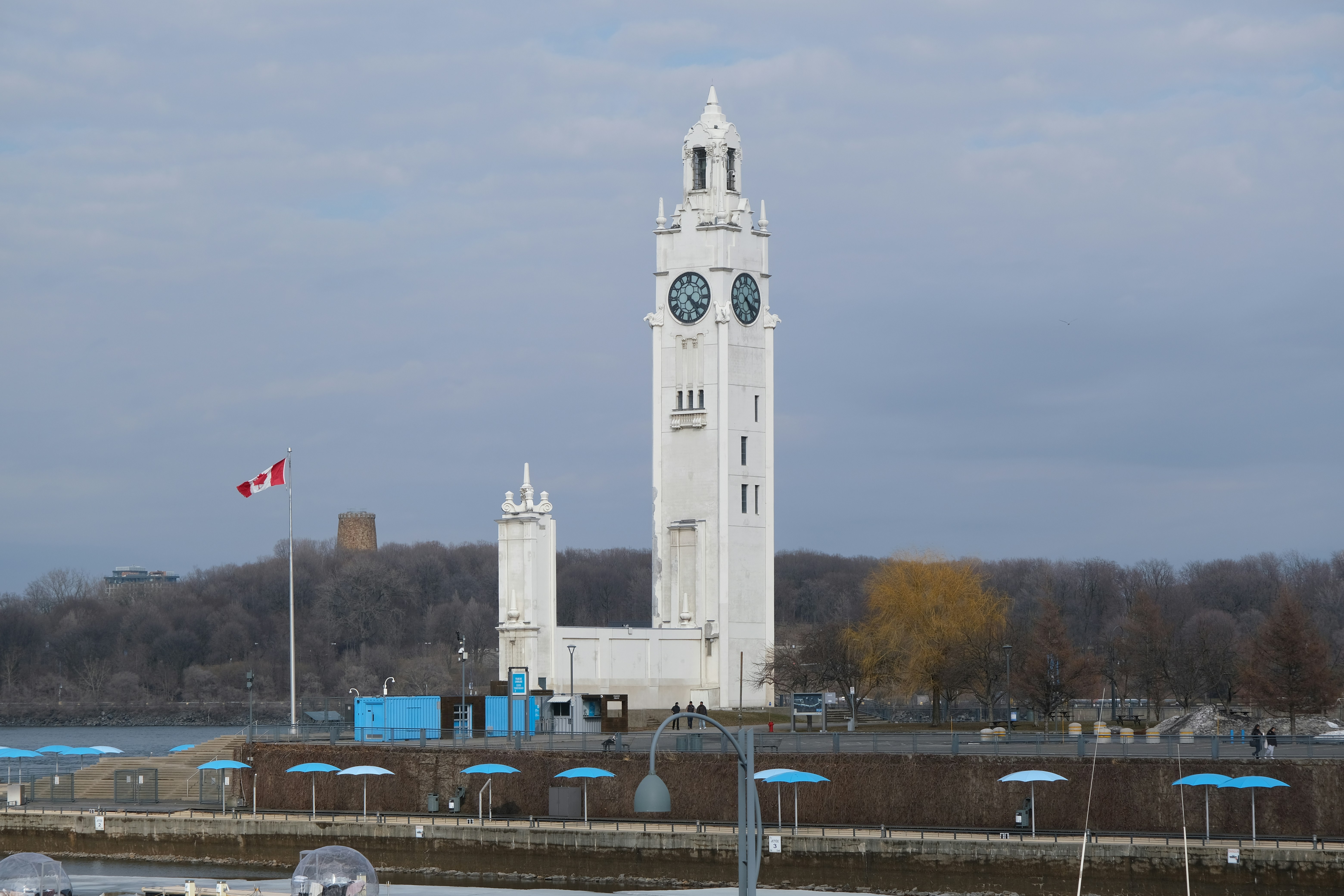 The Montreal Clock Tower on the waterfront with a Canadian flag nearby