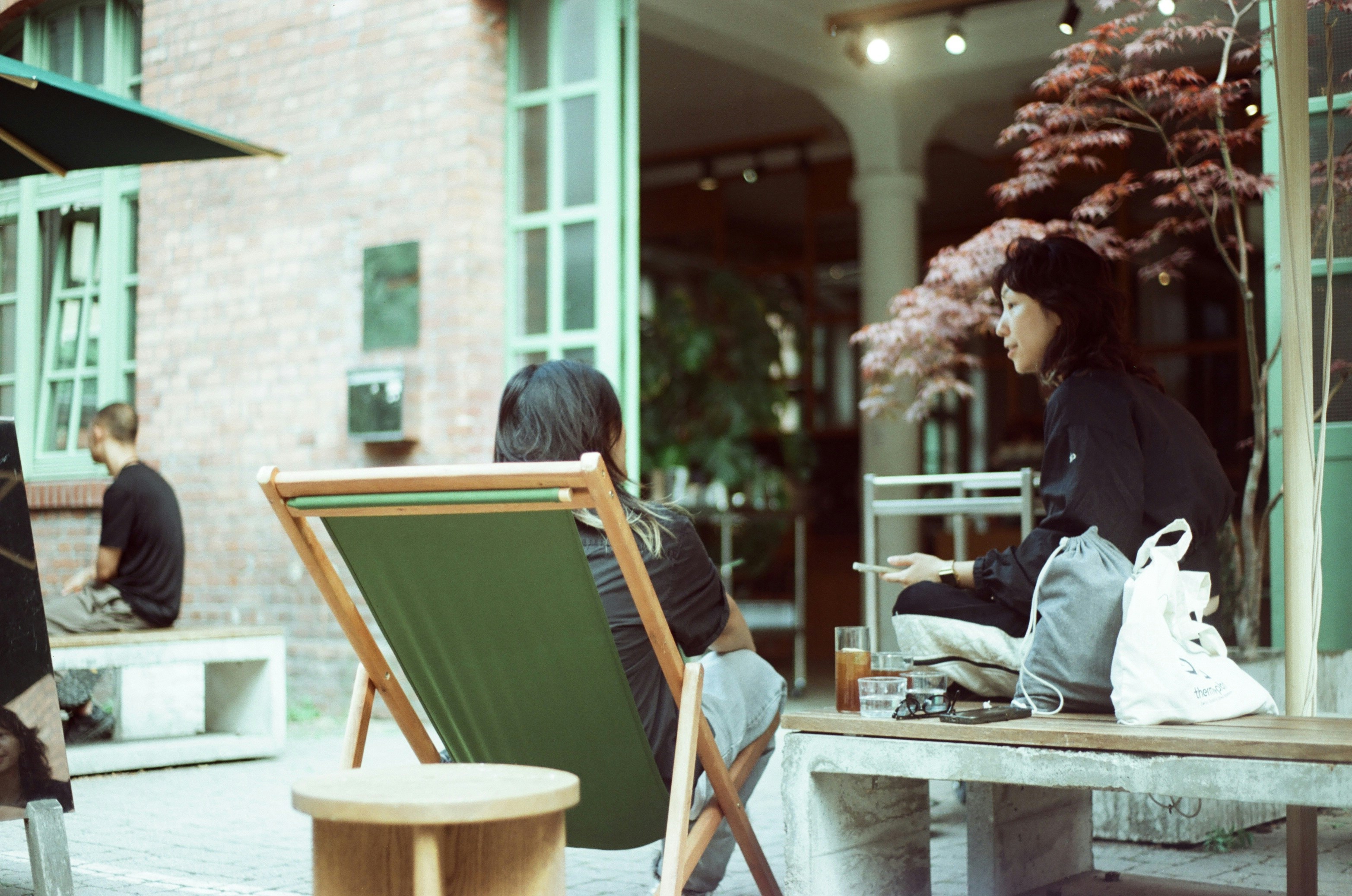 Two people chatting on a sunny cafe patio