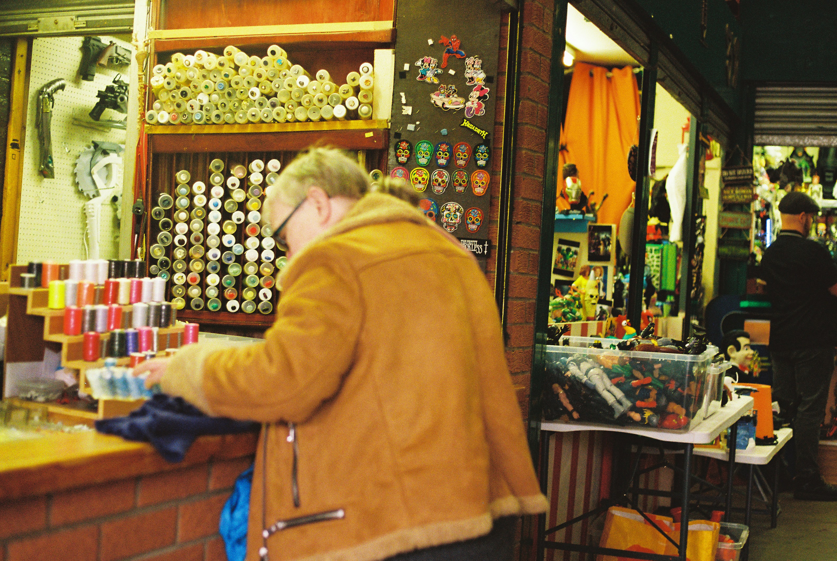 Shopper browsing spools of thread at a haberdashery