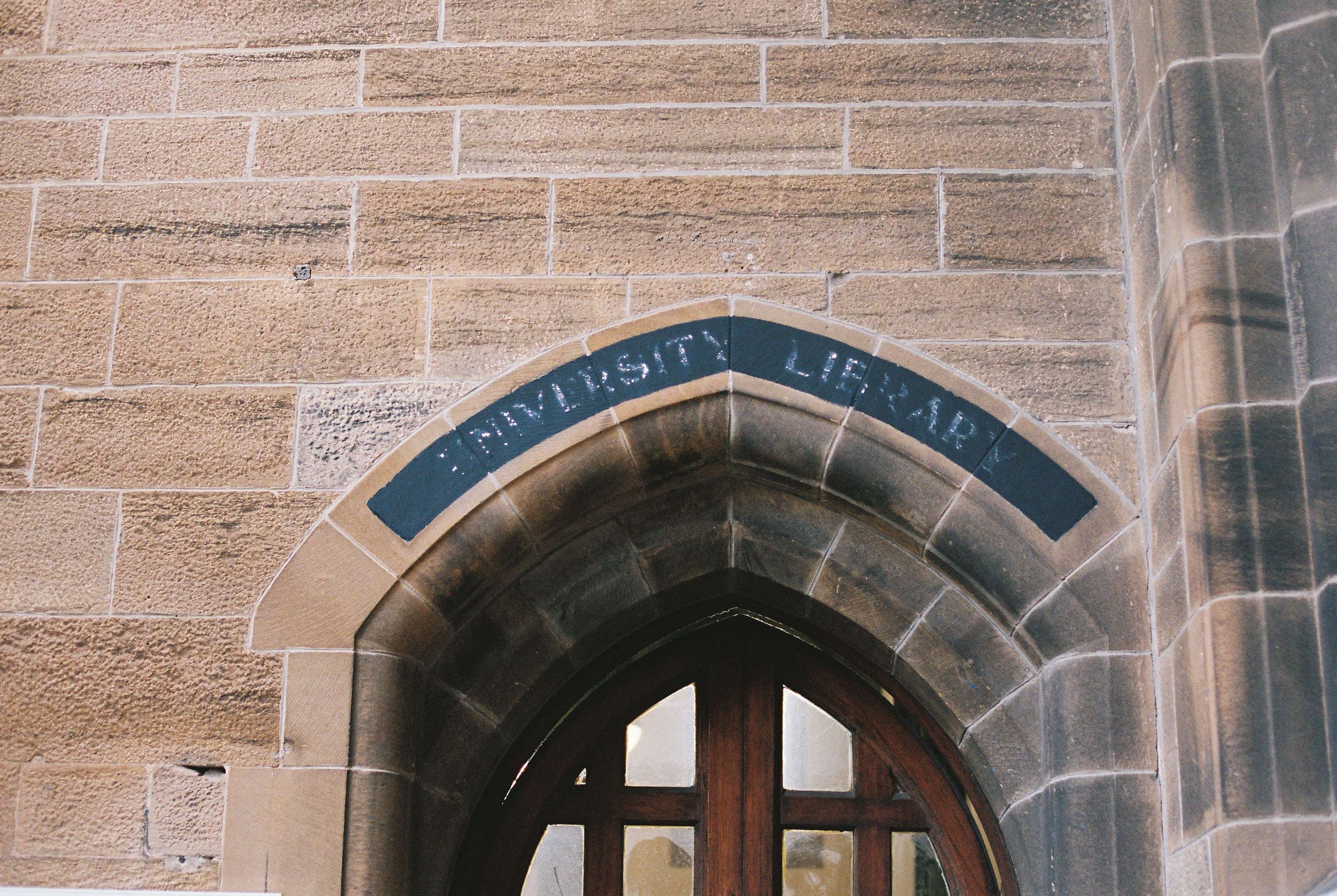 A carved stone archway with UNIVERSITY LIBRARY cut into the lintel
