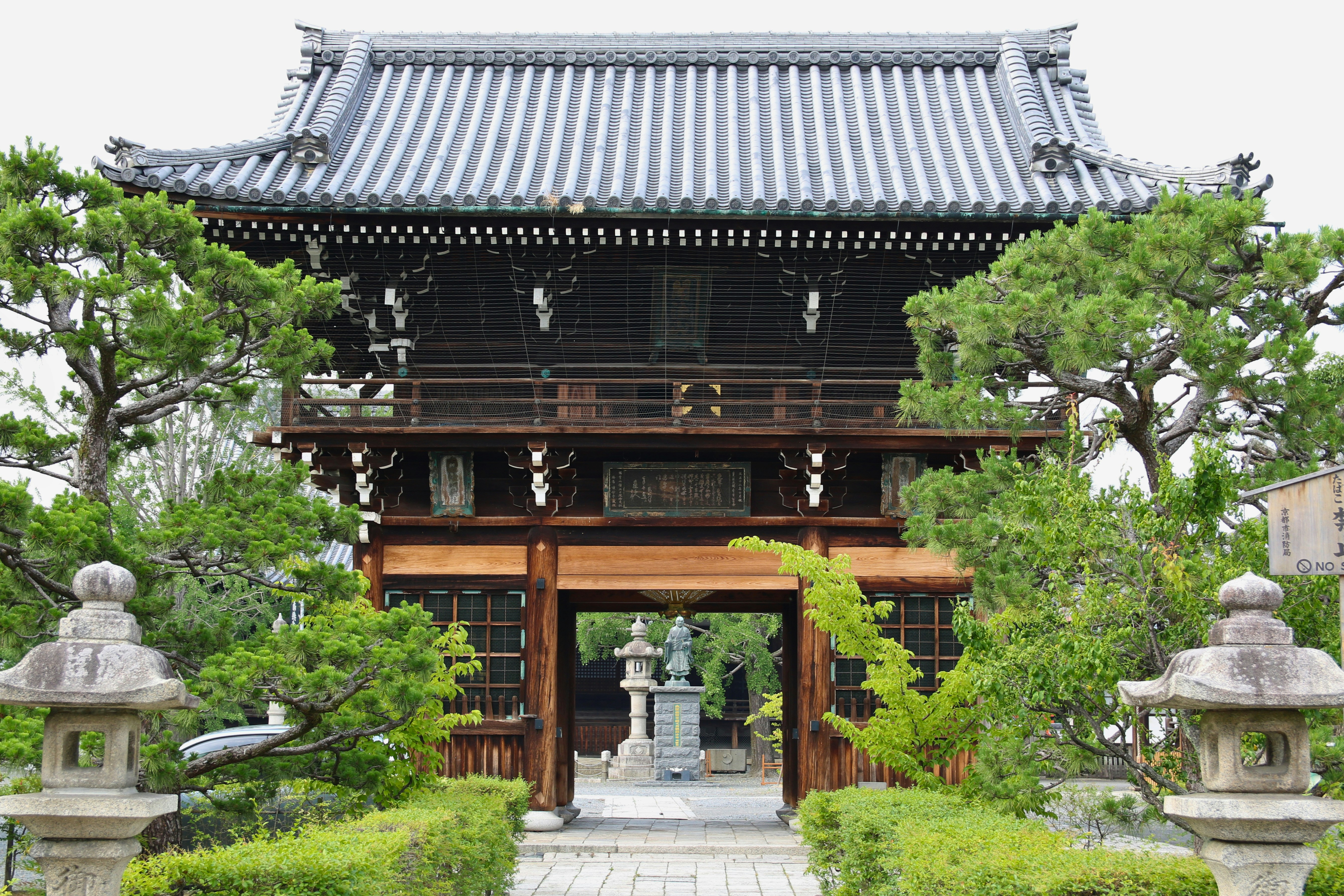 A wooden temple gate with a tiled roof in Kyoto, Japan