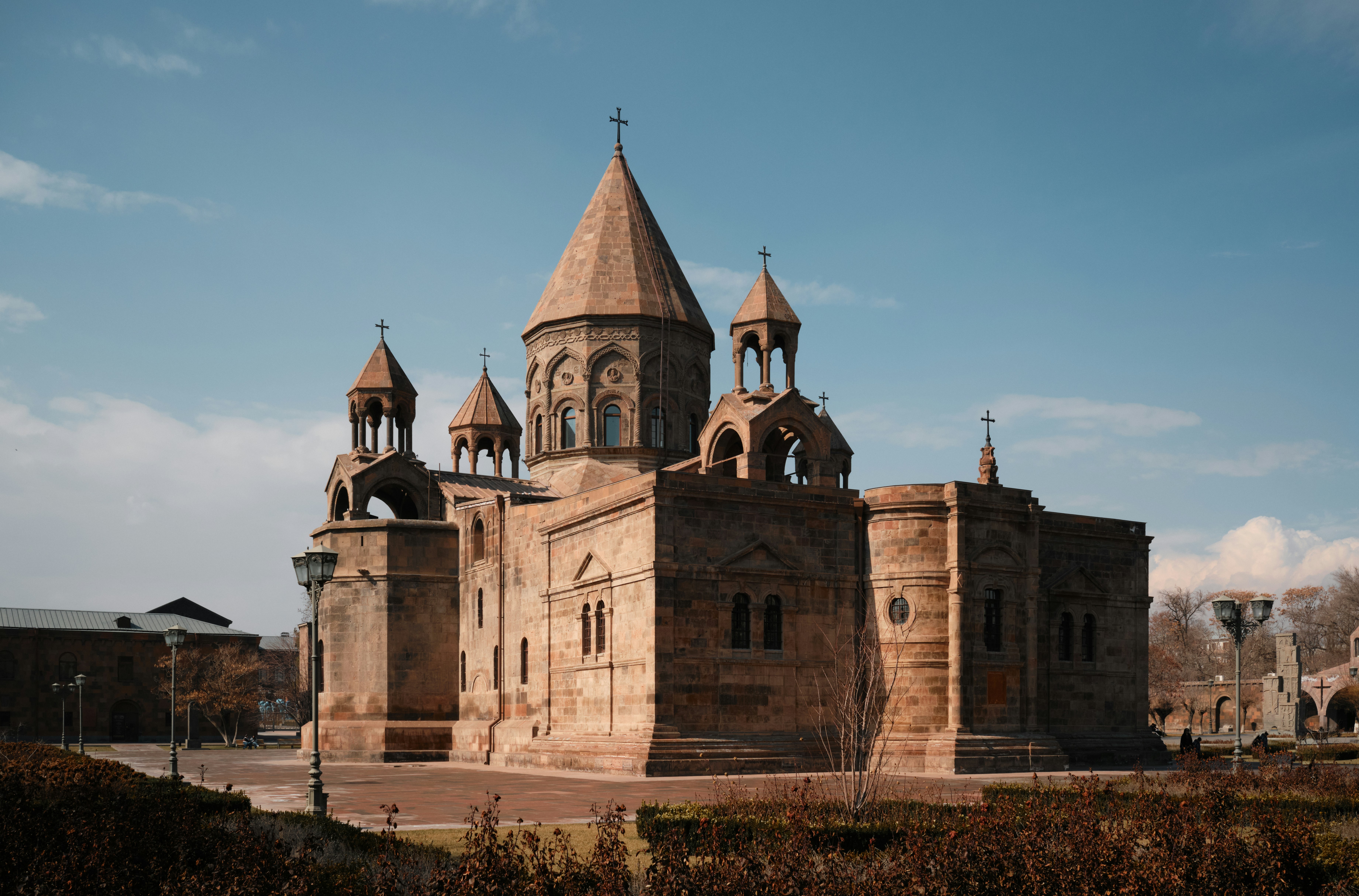 The Etchmiadzin Cathedral with its stone towers under a clear blue sky in Armenia