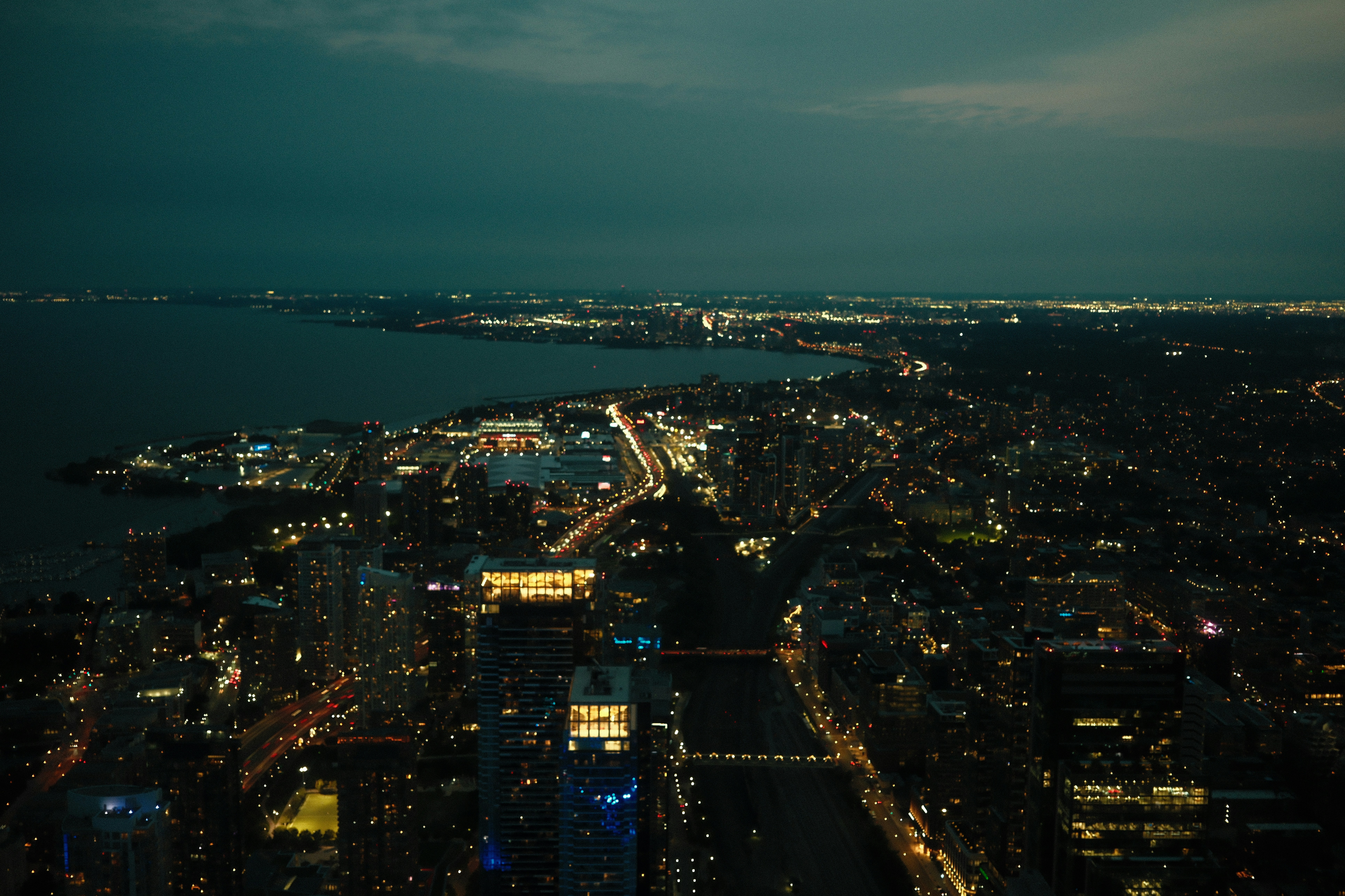 Aerial view of a city skyline at night with illuminated buildings and roads
