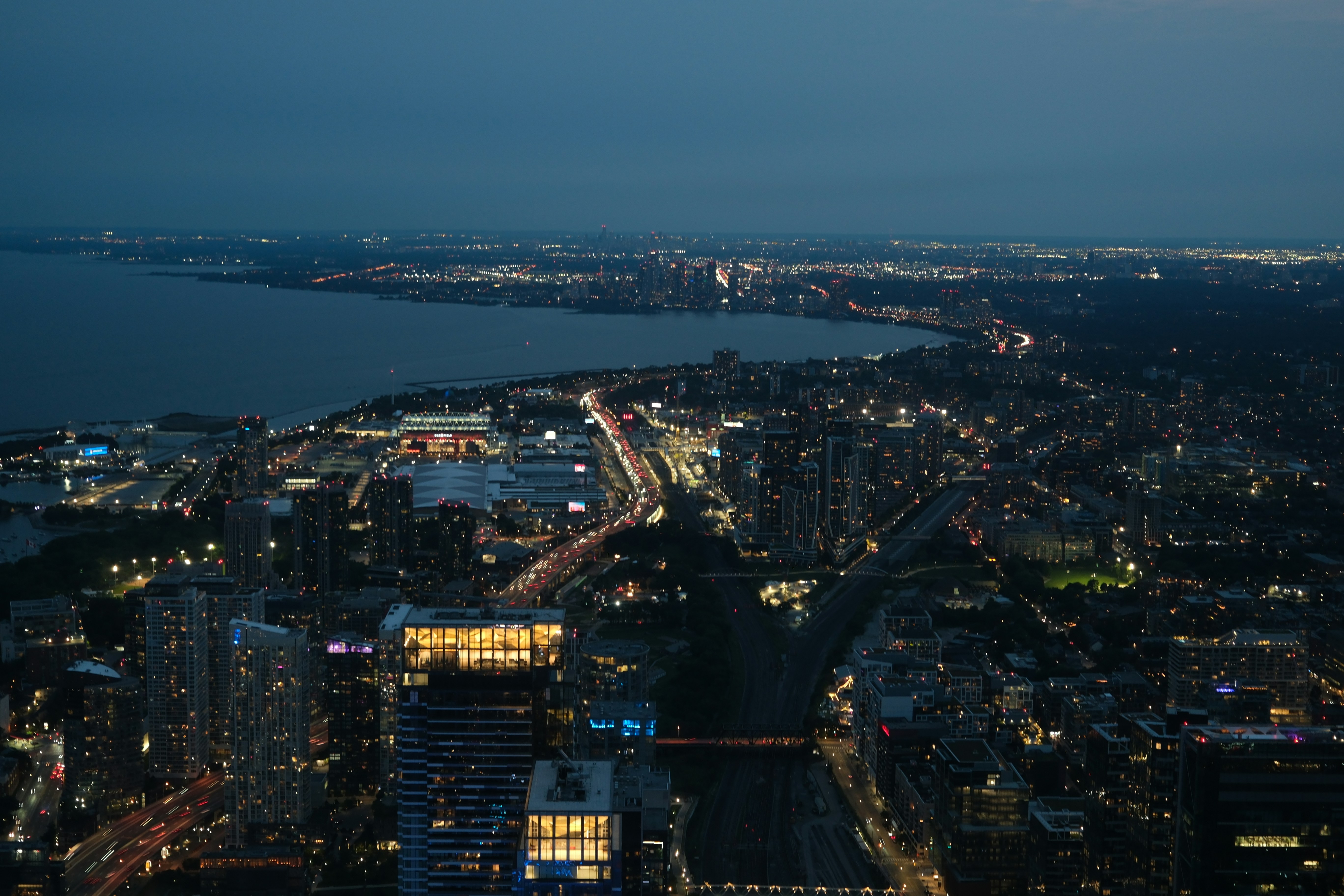 Aerial view of the Toronto skyline at night with illuminated buildings and traffic