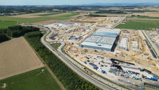 An aerial view of a large industrial construction site surrounded by agricultural fields