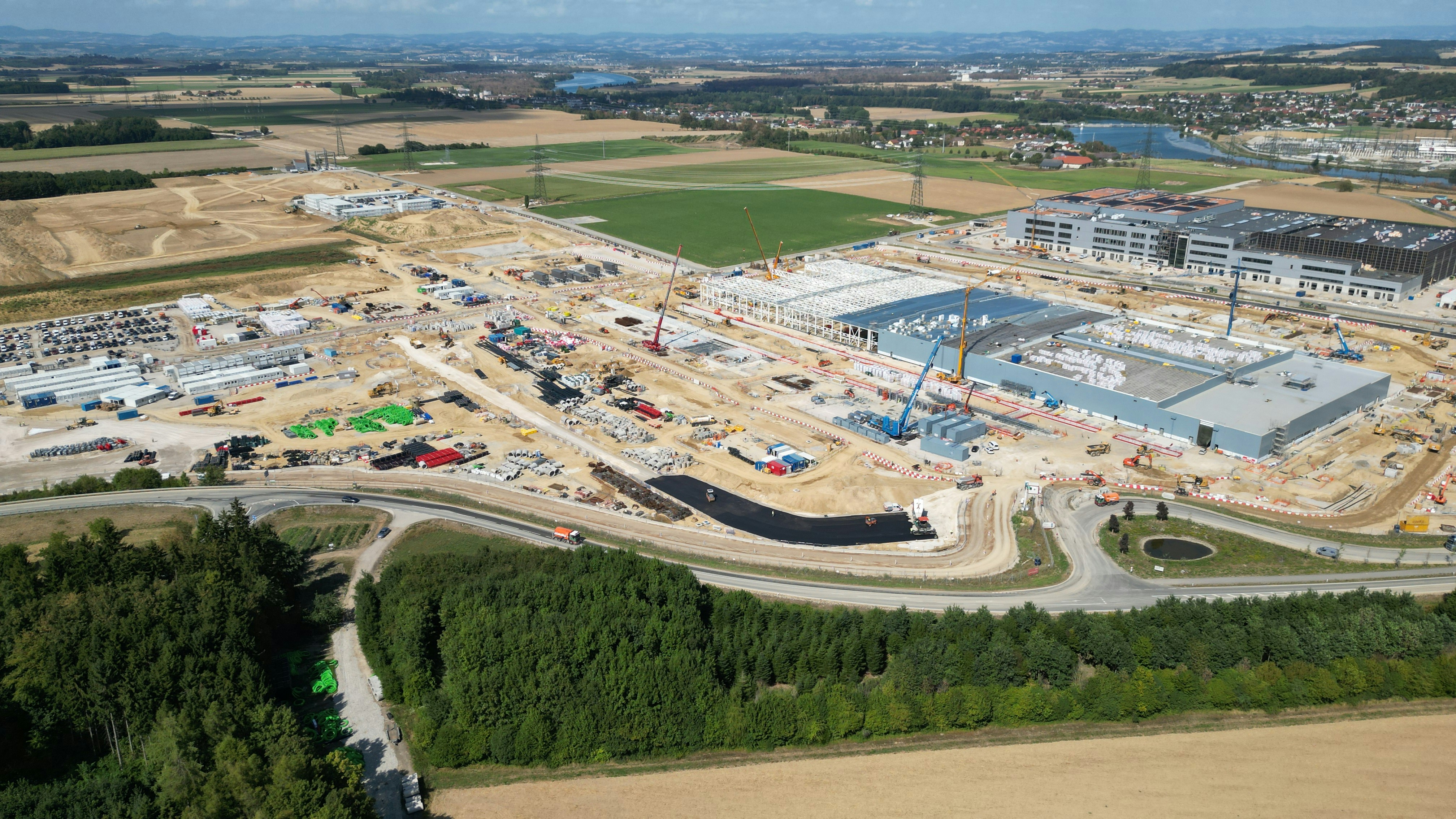 An aerial view of a large industrial construction site with cranes and machinery
