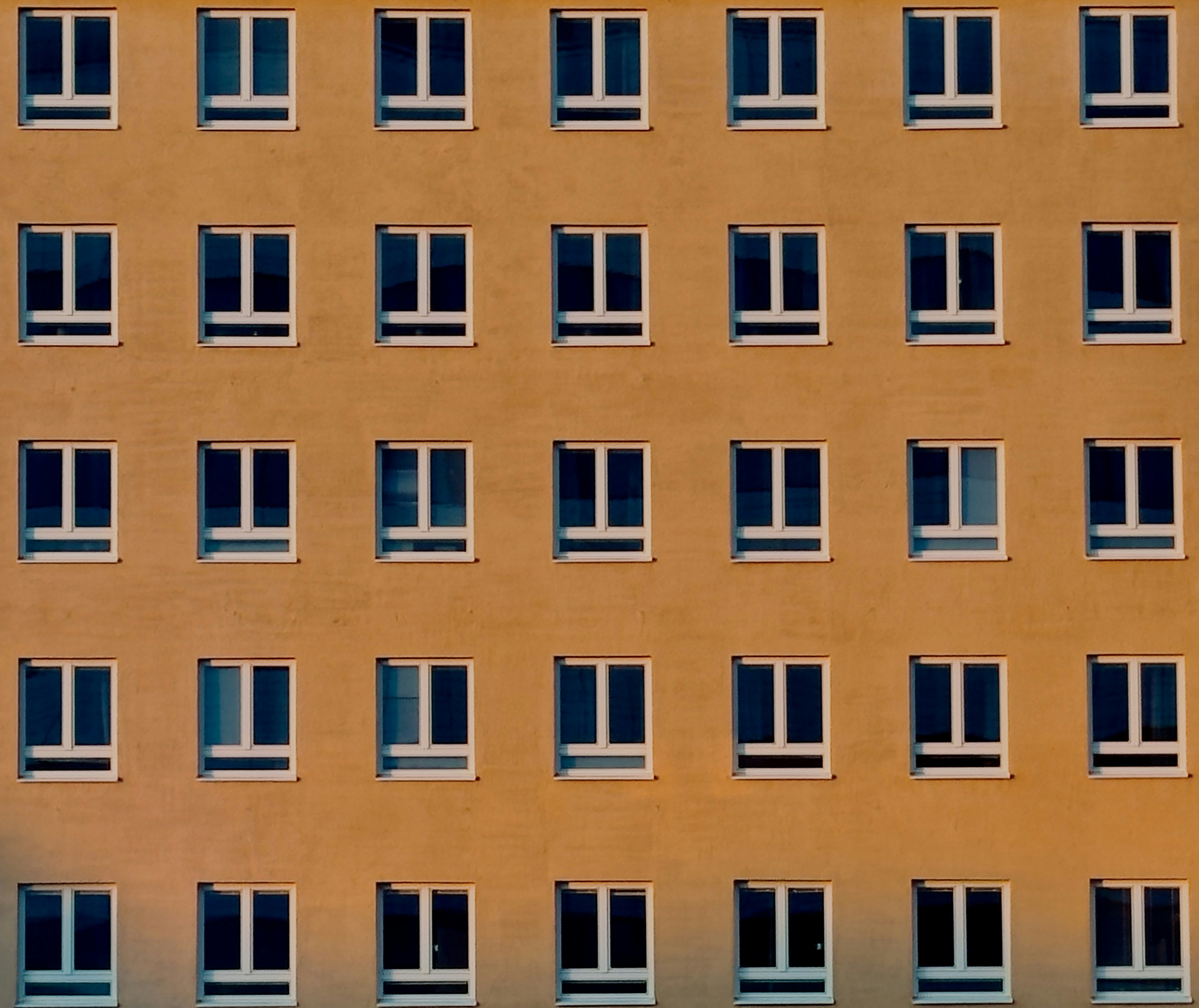 Grid of uniform windows on an orange facade