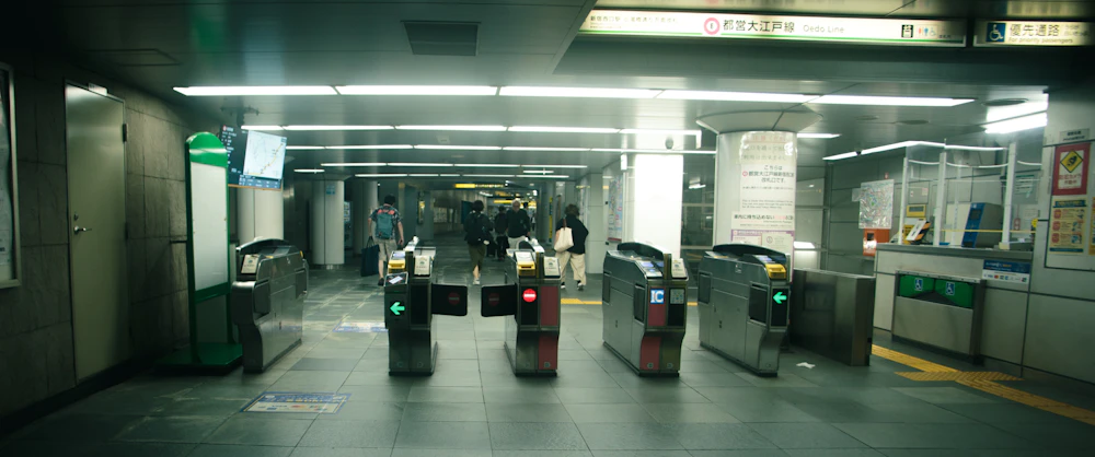 Commuters tapping through ticket gates at a Tokyo subway station