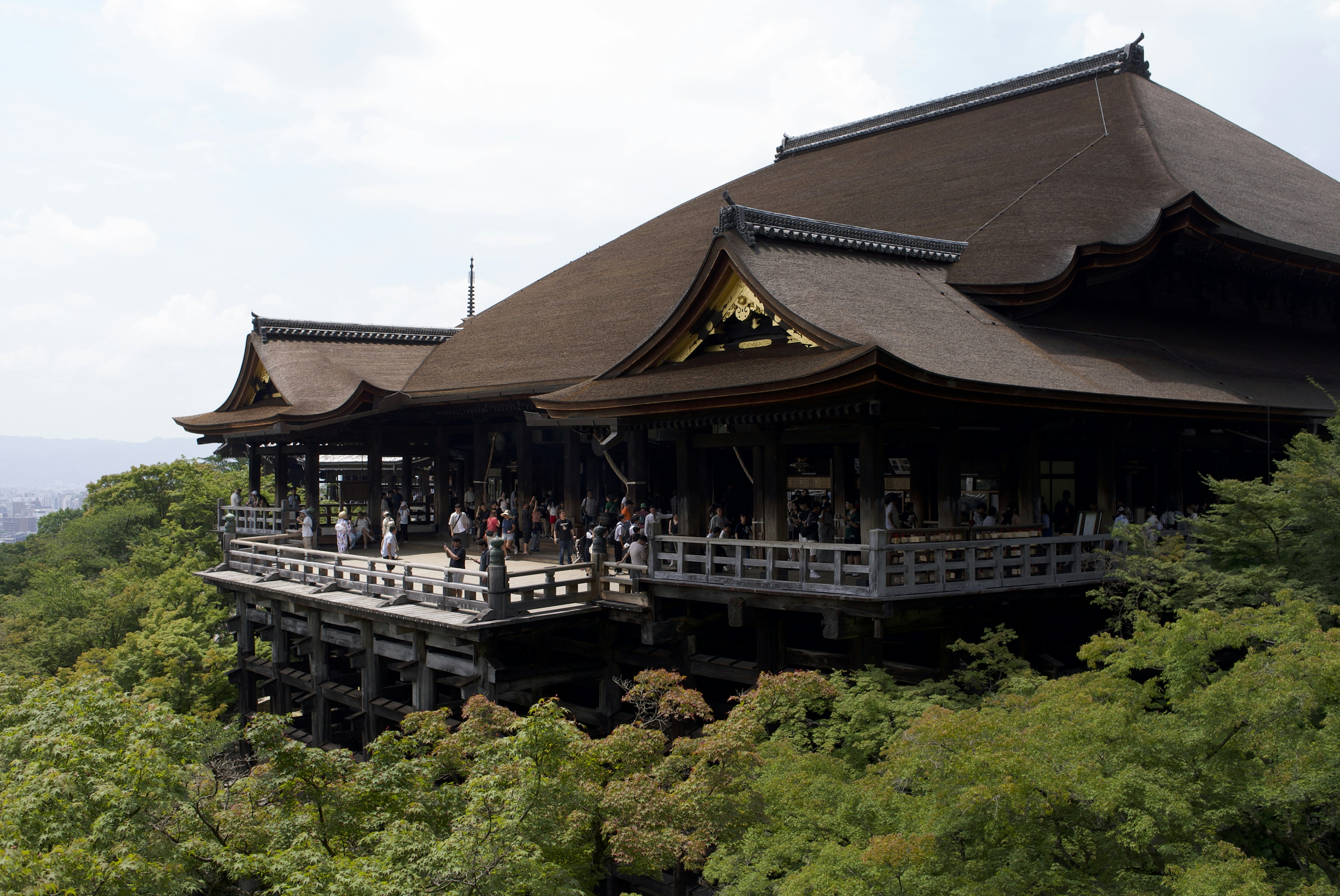 Visitors on the wooden veranda of Kiyomizu-dera temple in Kyoto, Japan